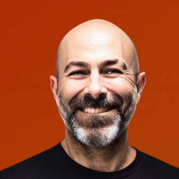 Smiling middle-aged man with a bald head and gray beard against an orange background.