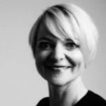 Black and white photo of a woman with short blonde hair smiling.