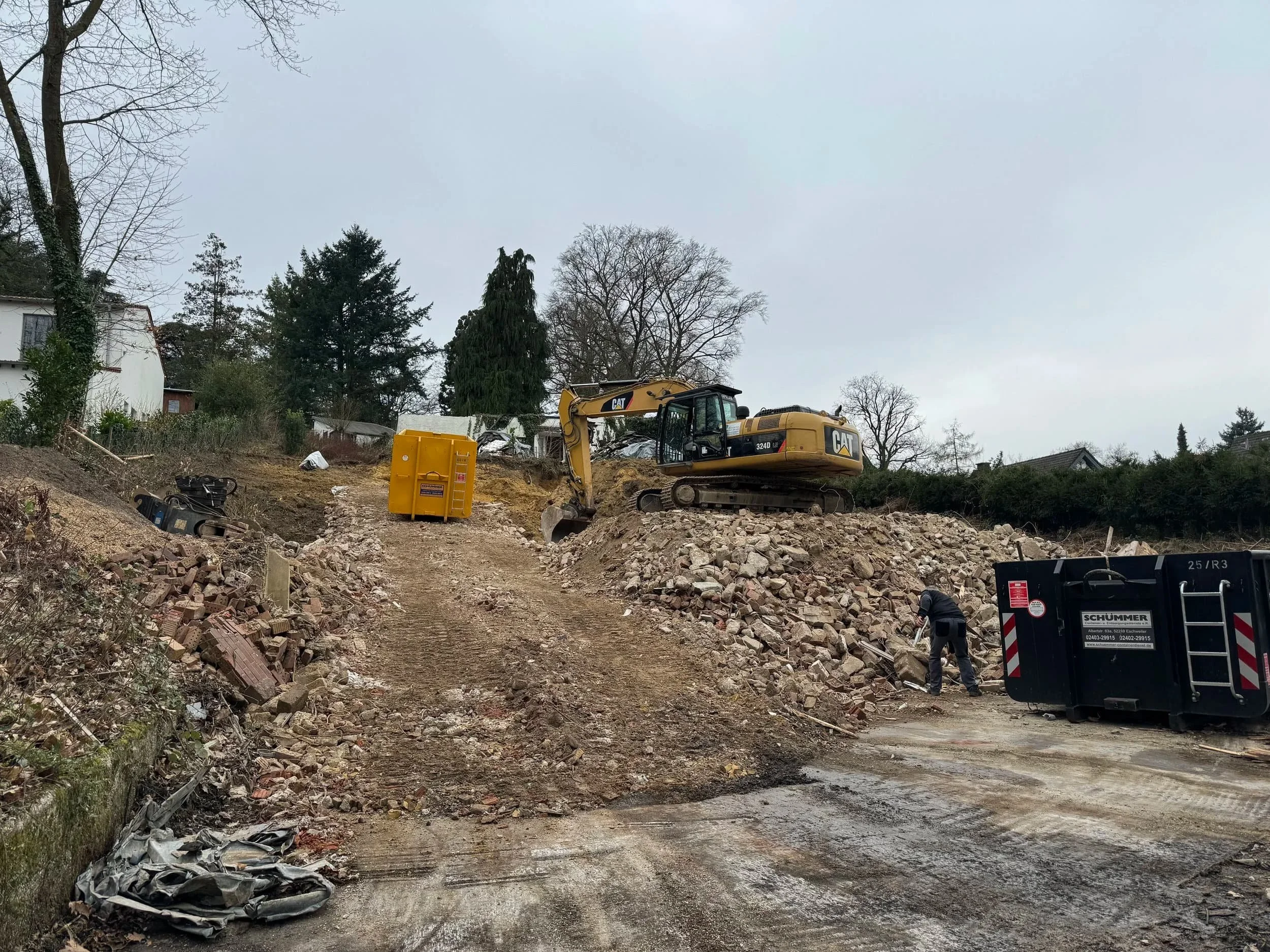 Laden von Abfällen mit einem Bagger in einen Container in Aachen durch Steeg Abbruch