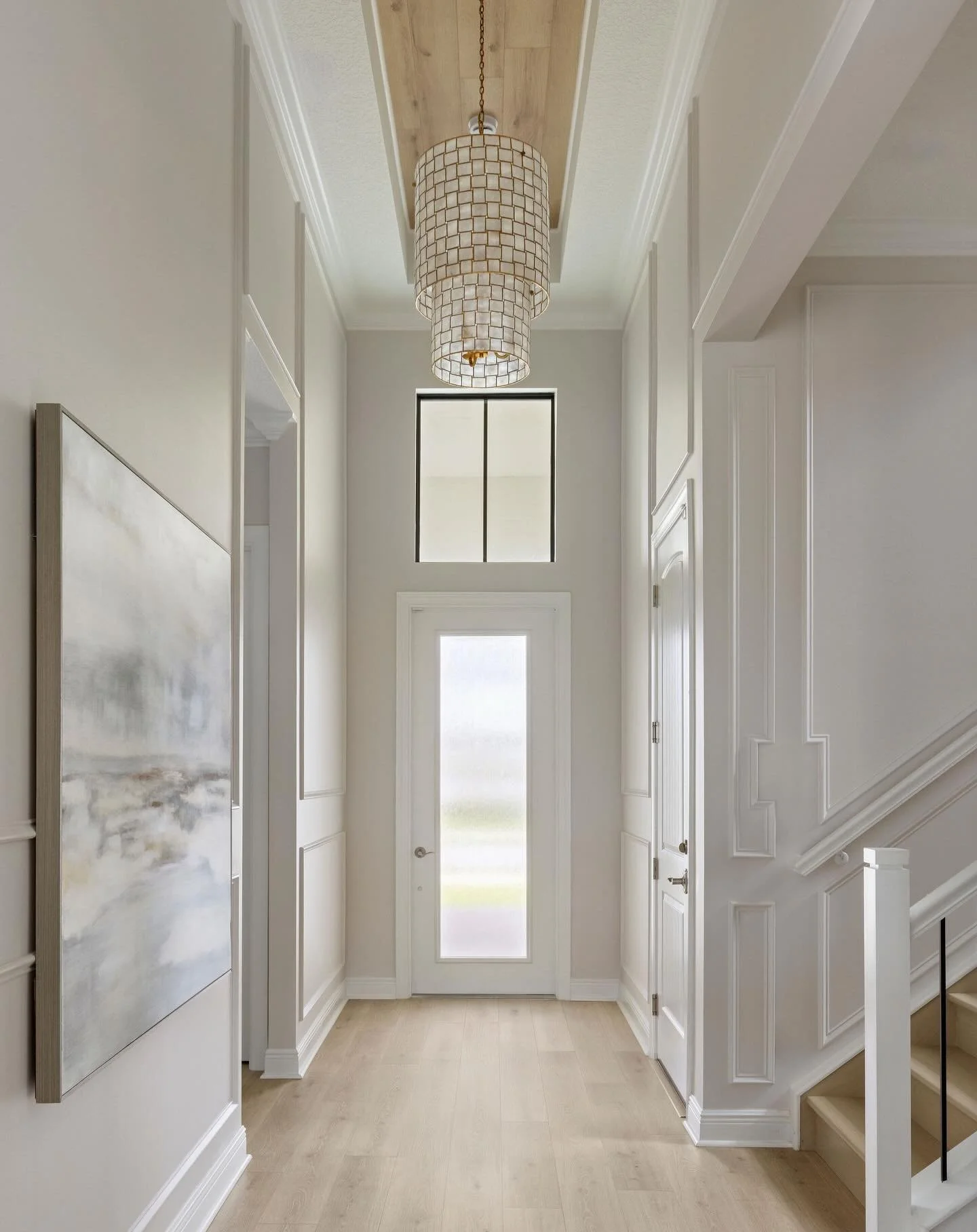A light-filled entry that sets the tone from the moment you walk in&mdash;layered millwork, soft tones, and warm floors creating a refined yet welcoming foundation. 

The custom ceiling detail draws the eye upward, perfectly framing the capiz chandel