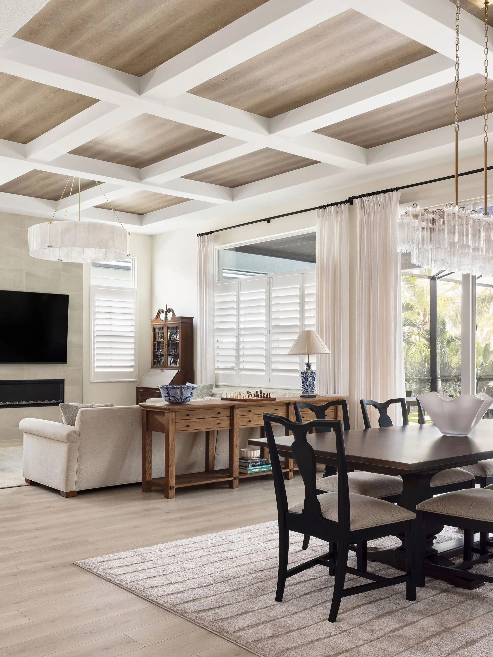 The ceiling is the real showstopper here 🥹

Mixing traditional with contemporary elements - 
A wood ceiling with white beams grounds this entire great room and dining space, while antique accents and a linear fireplace keep it feeling intentionally 