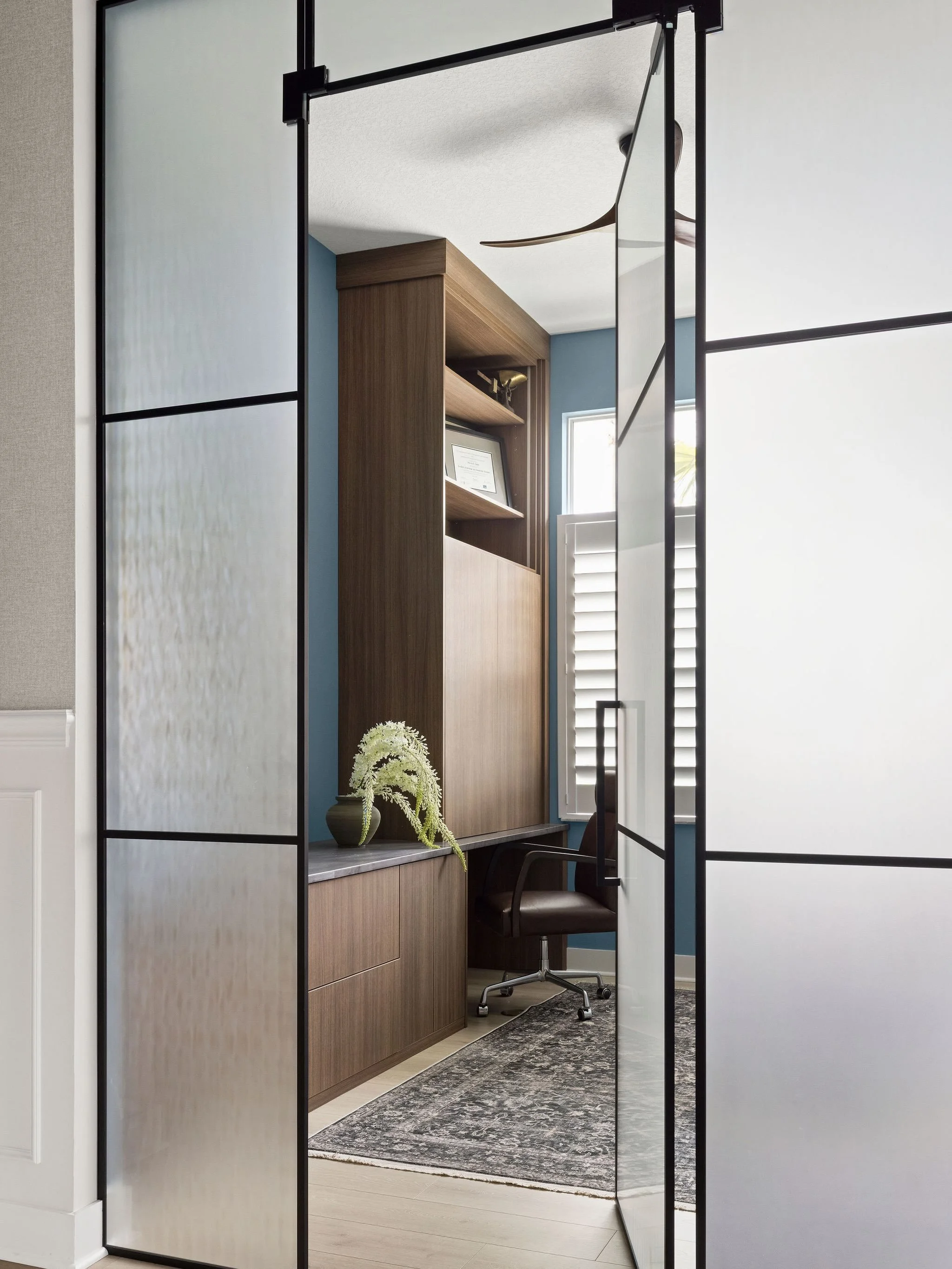 A hidden workspace is easily one of the most requested features we hear from our clients - and this one proved that function can still be elevated. 

Custom frosted-glass grid doors create a beautiful architectural moment while keeping the office tuc