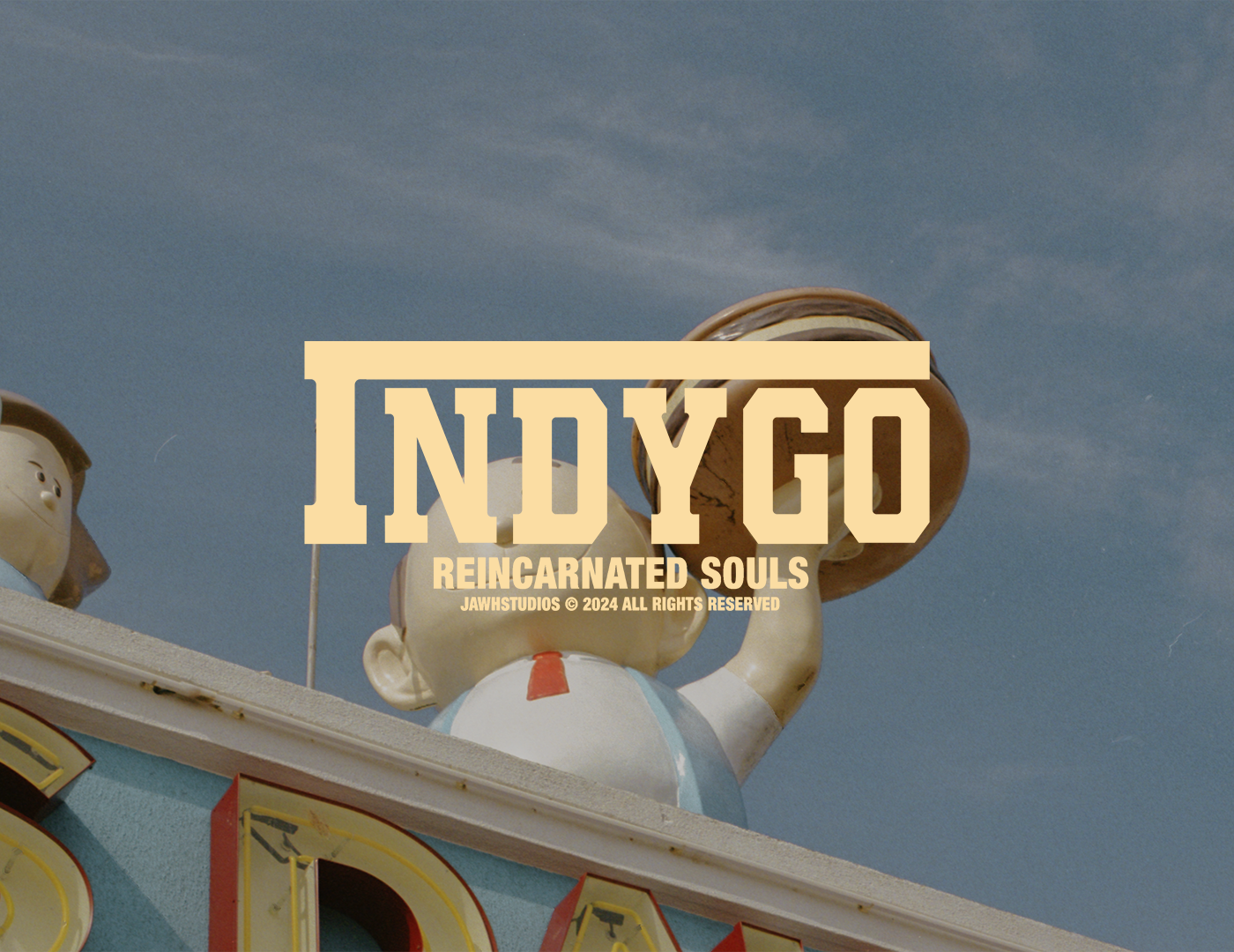 A vintage carnival game with colorful mascot characters on a blue sky background, featuring large lettering that says 'INDY GO' and smaller text 'Reincarnated Souls'.