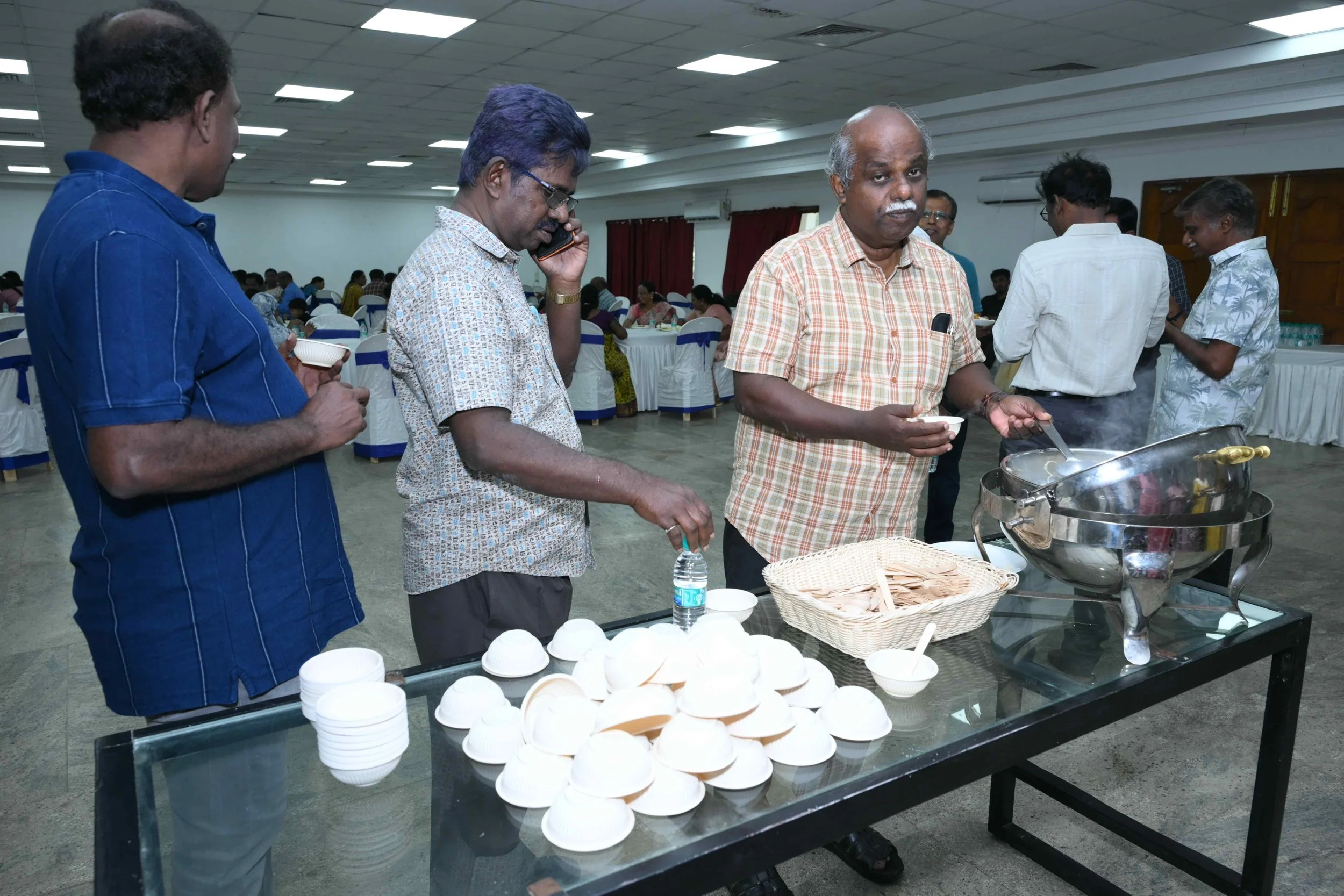 Charles phones someone to ask if he should eat this. Kamalesh waits for an answer.