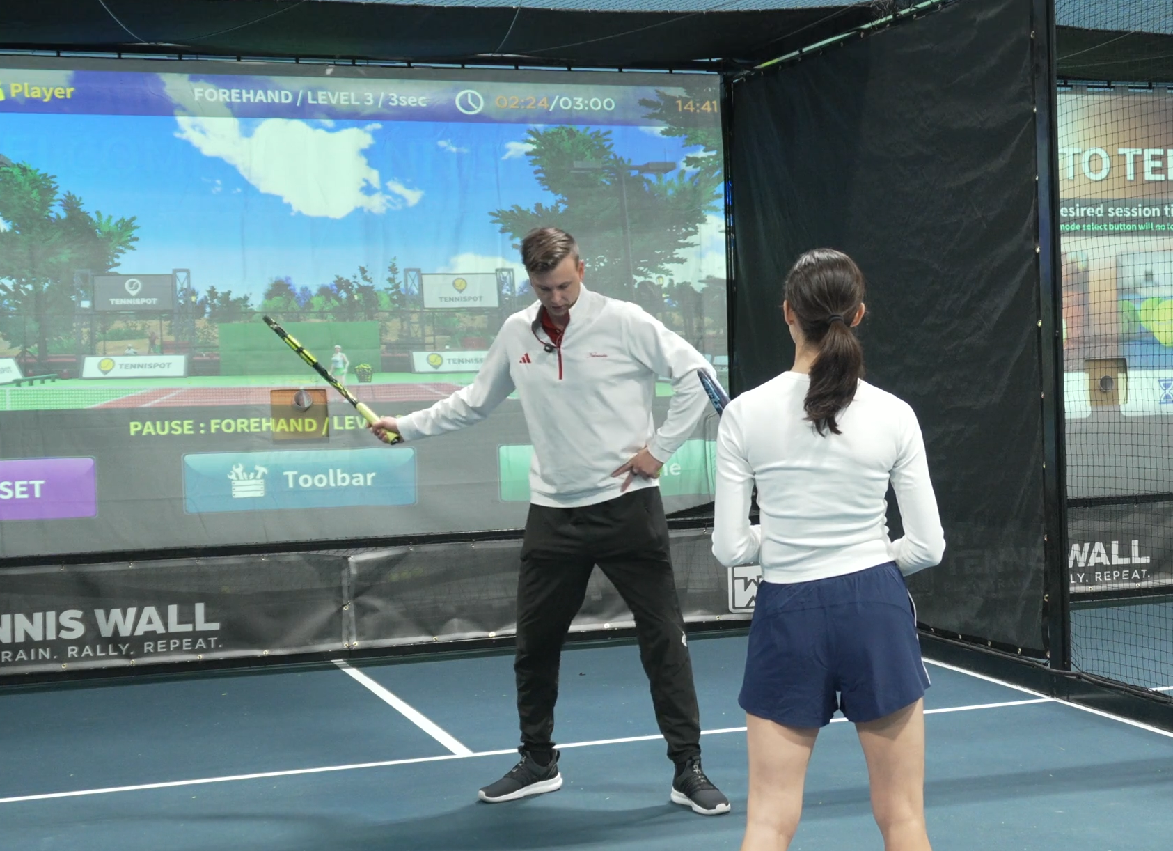 coaching a tennis player with the tennis simulator in houston heights indoors