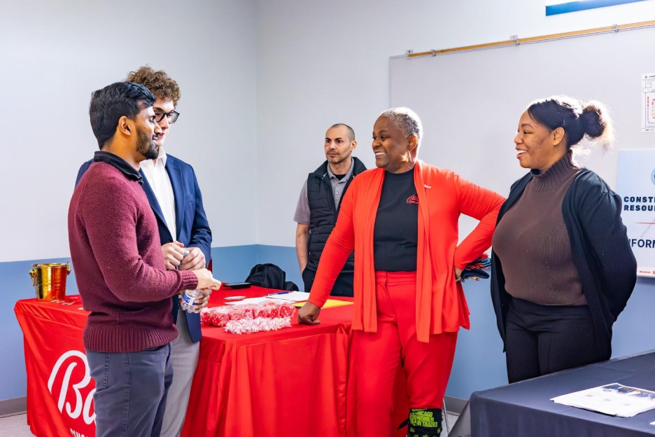  Denisha Broida (far right), the fair’s lead coordinator and Community Impact and Engagement Manager, and Gerri Harris, Community Impact and Engagement Lead, both for CCBC joint venture partner Gilbane Building, speaks with fair attendees at the Ball