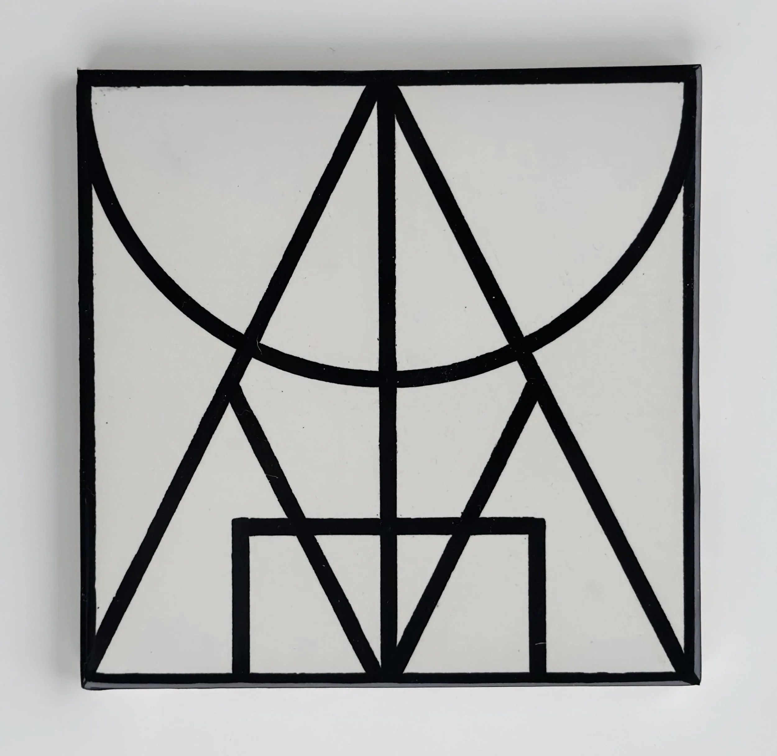 Black geometric wall art with various straight lines and semicircles, framed and mounted on a white wall.