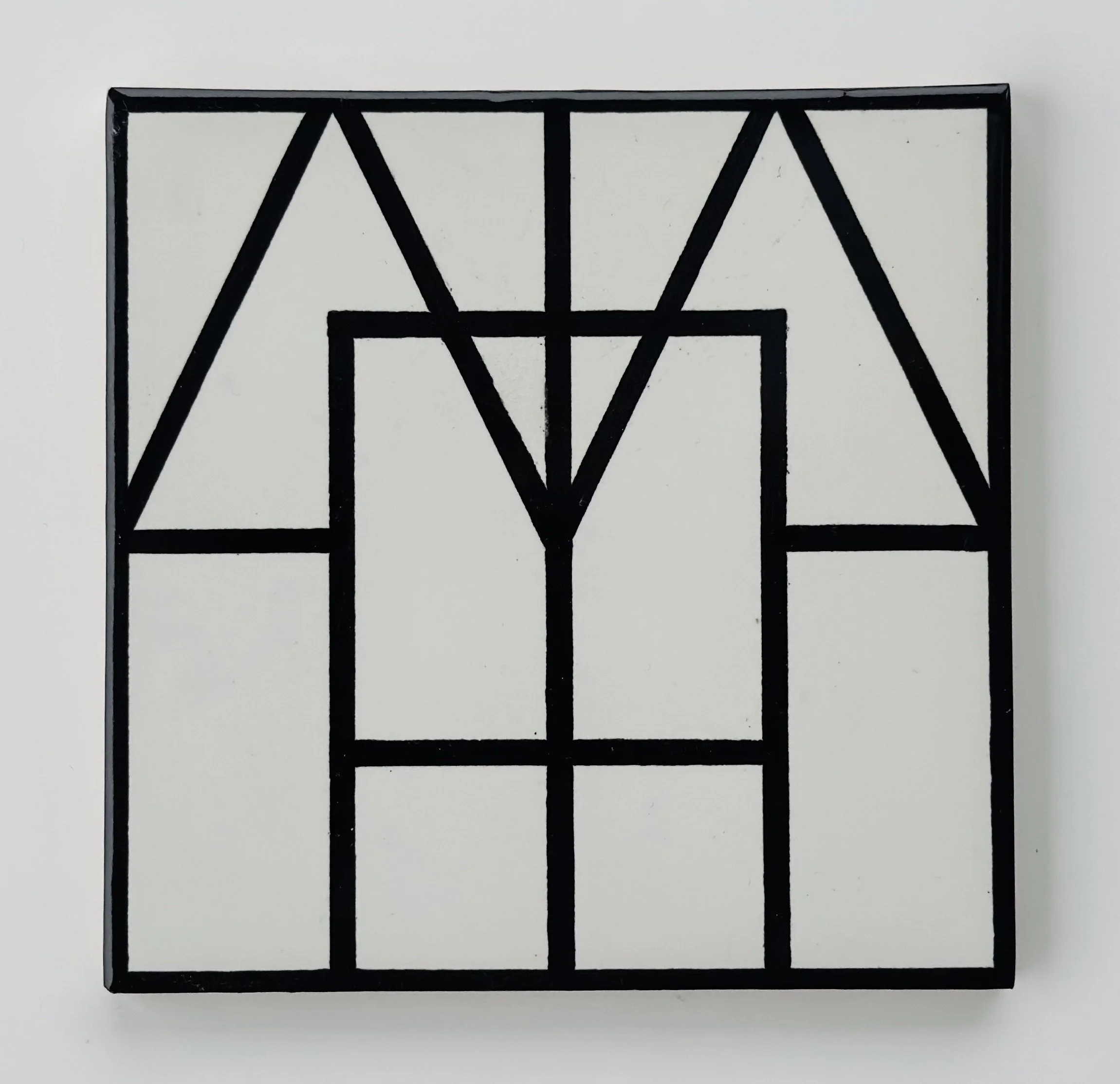 Abstract wall art with a black geometric pattern on a white background.