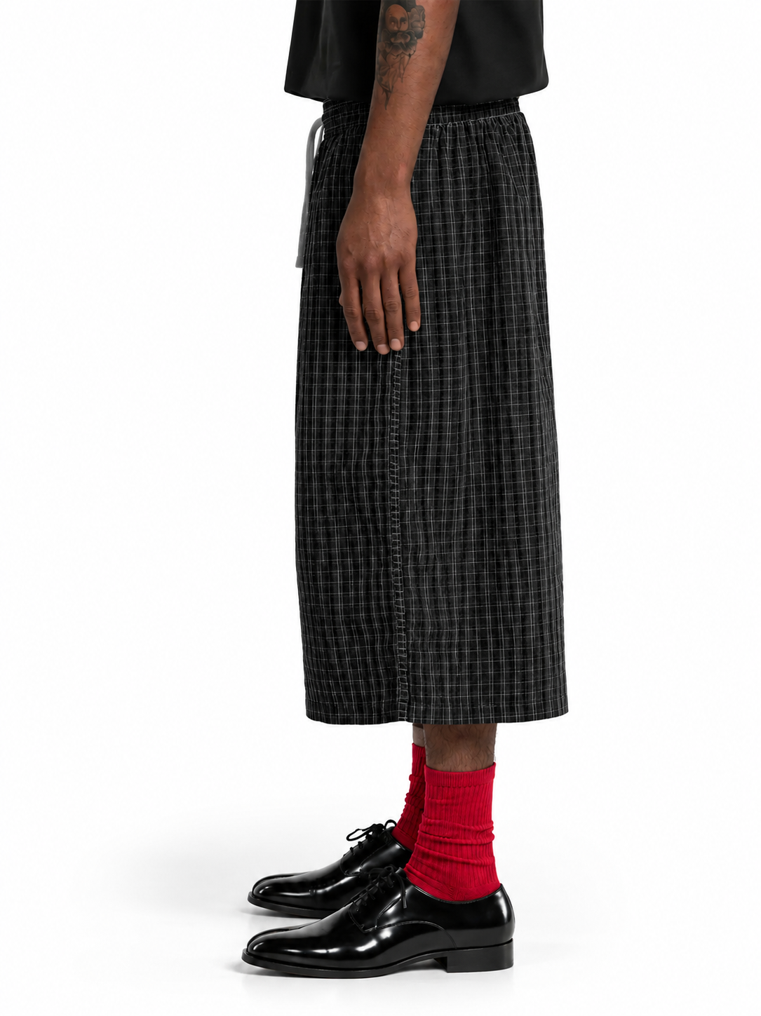 Side-view model in baggy black plaid pants.png