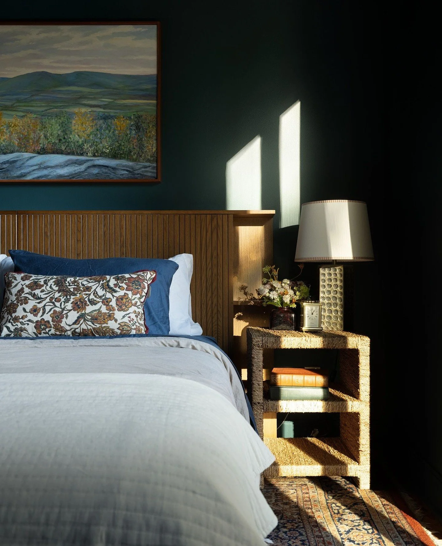 The primary bedroom was designed to feel like a true retreat. Color wraps the room completely, creating a sense of calm and continuity that makes it easy to settle in. Warm wood tones add balance, and the glass doors open the space to the outdoors, l