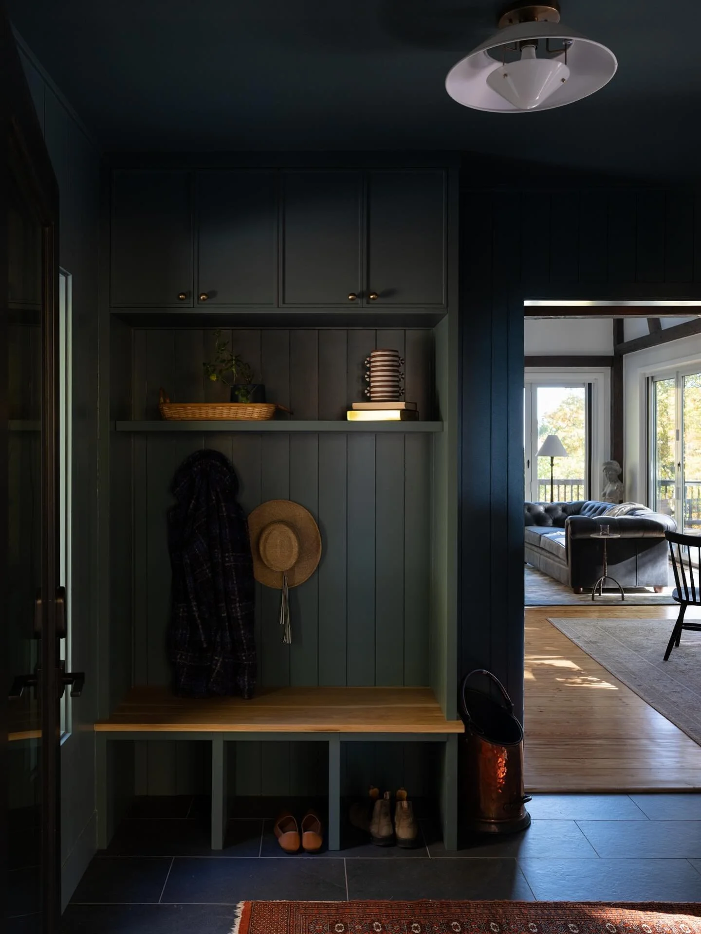 The mudroom ties directly into the porch addition with the same black matte porcelain tile carried inside. It keeps the transition clean and intentional.

Cabinetry is from Nieu in Sweetly Sage, and we matched the nickel gap walls to the cabinet fr