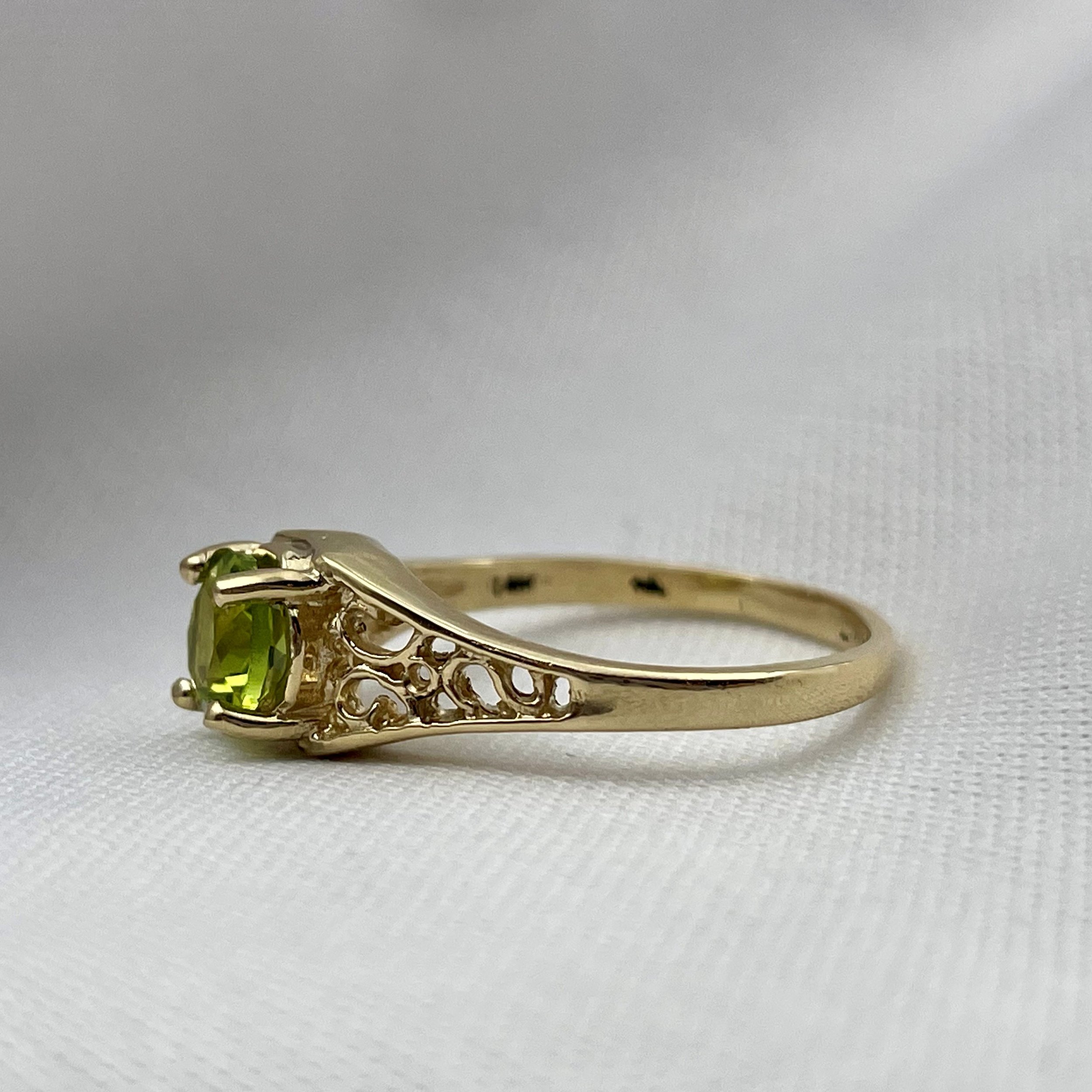 side view of 14k Yellow Gold 6mm Round Peridot With Filigree Shoulders Ladies Ring with white background