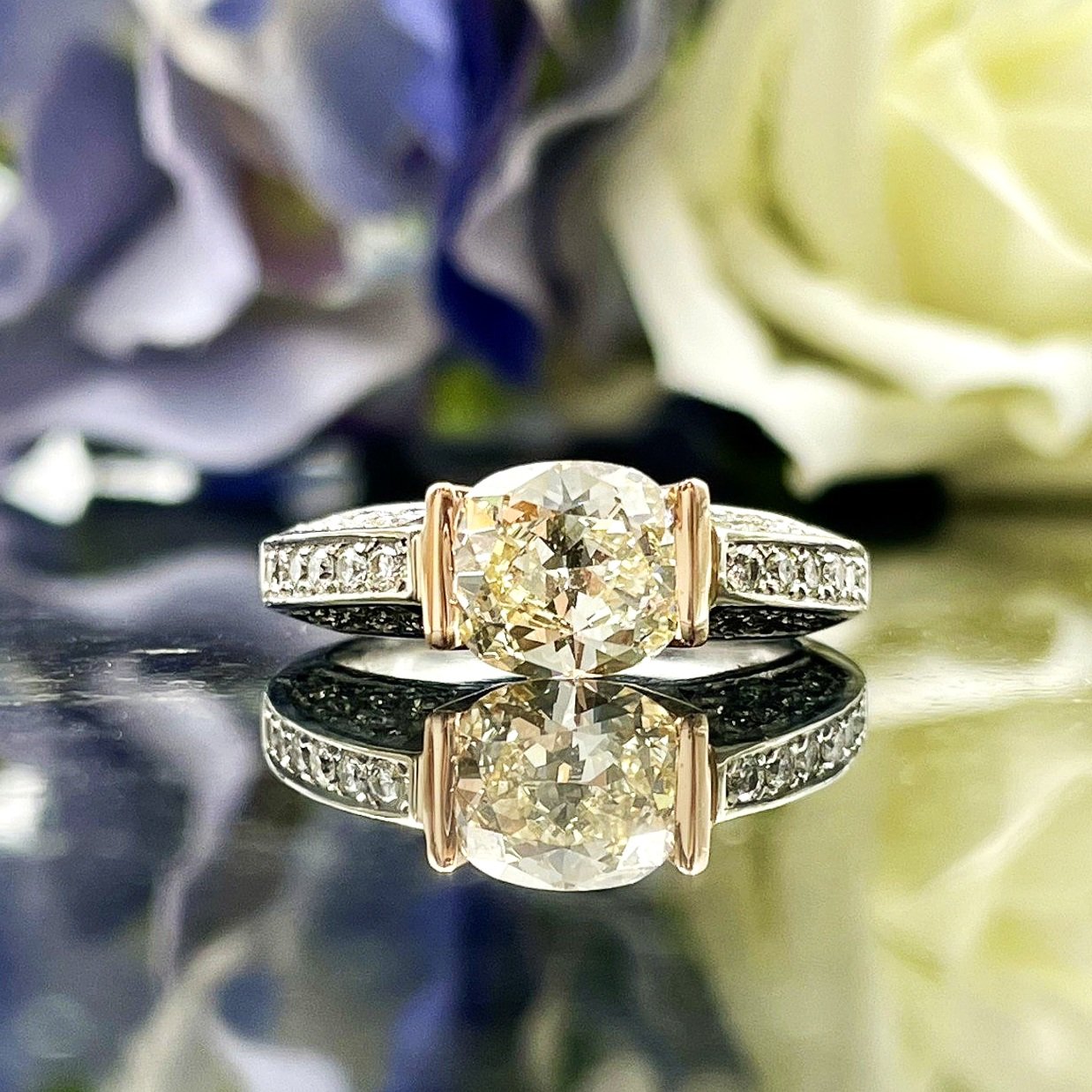 close up in front of flowers 1.53ct Cushion Cut Diamond Two Tone 14k White And Rose Gold Engagement Ring