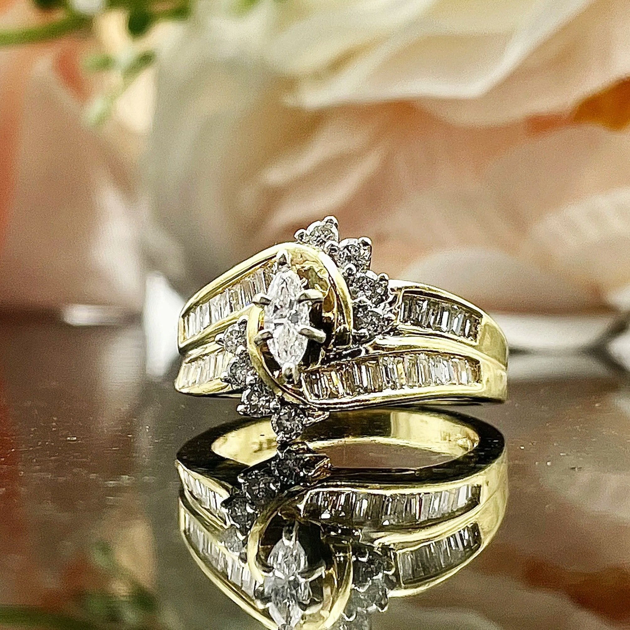 front view of 1.00ctw Marquise Diamond Statement Ring Engagement Anniversary 14k Yellow Gold flowers in background