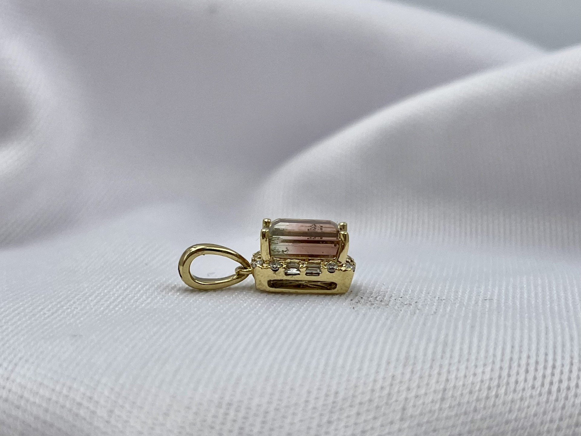 18k Yellow Gold .97ct Bi-Color Tourmaline With Diamond Halo Pendant side view in front of white cloth