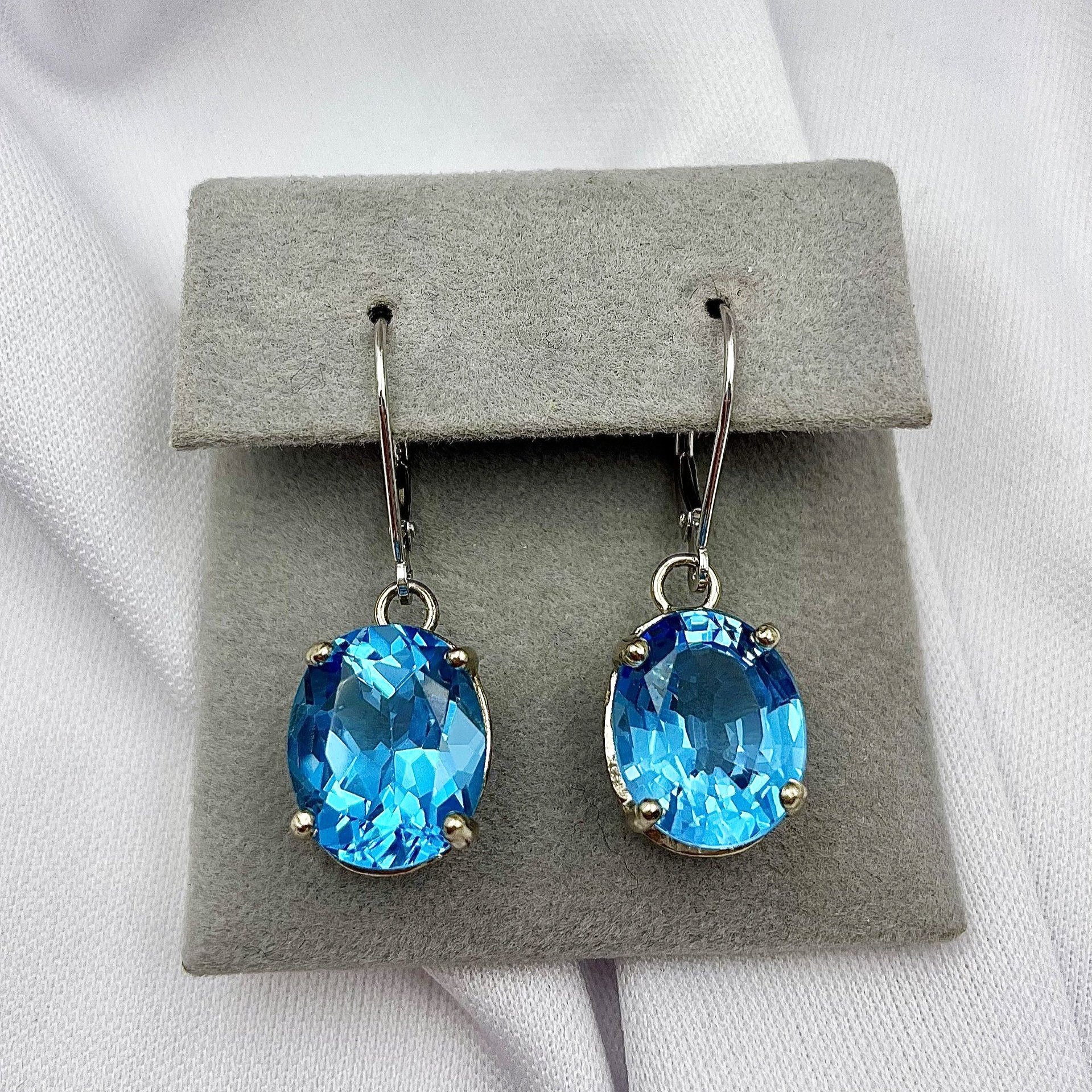 top down white background 14k White Gold 12x10mm Oval Cut Blue Topaz Drop Earrings