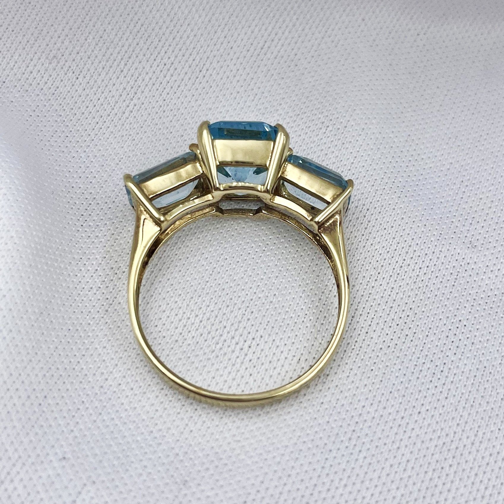 top down gallery view 10k Yellow Gold Emerald Cut Blue Topaz Three Stone Ring