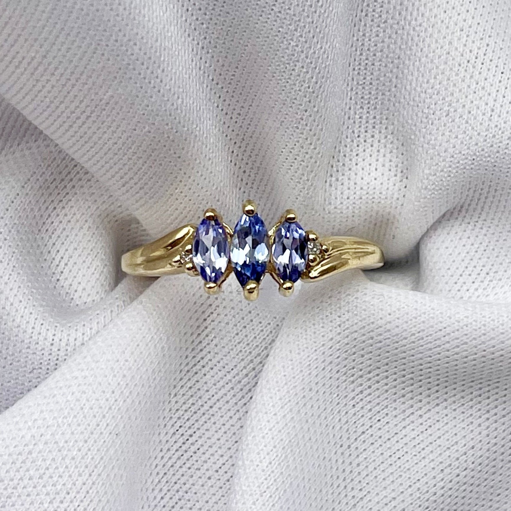 top down view white background Marquise Cut Three Stone Tanzanite Ring With Diamond Accents 10k Yellow Gold