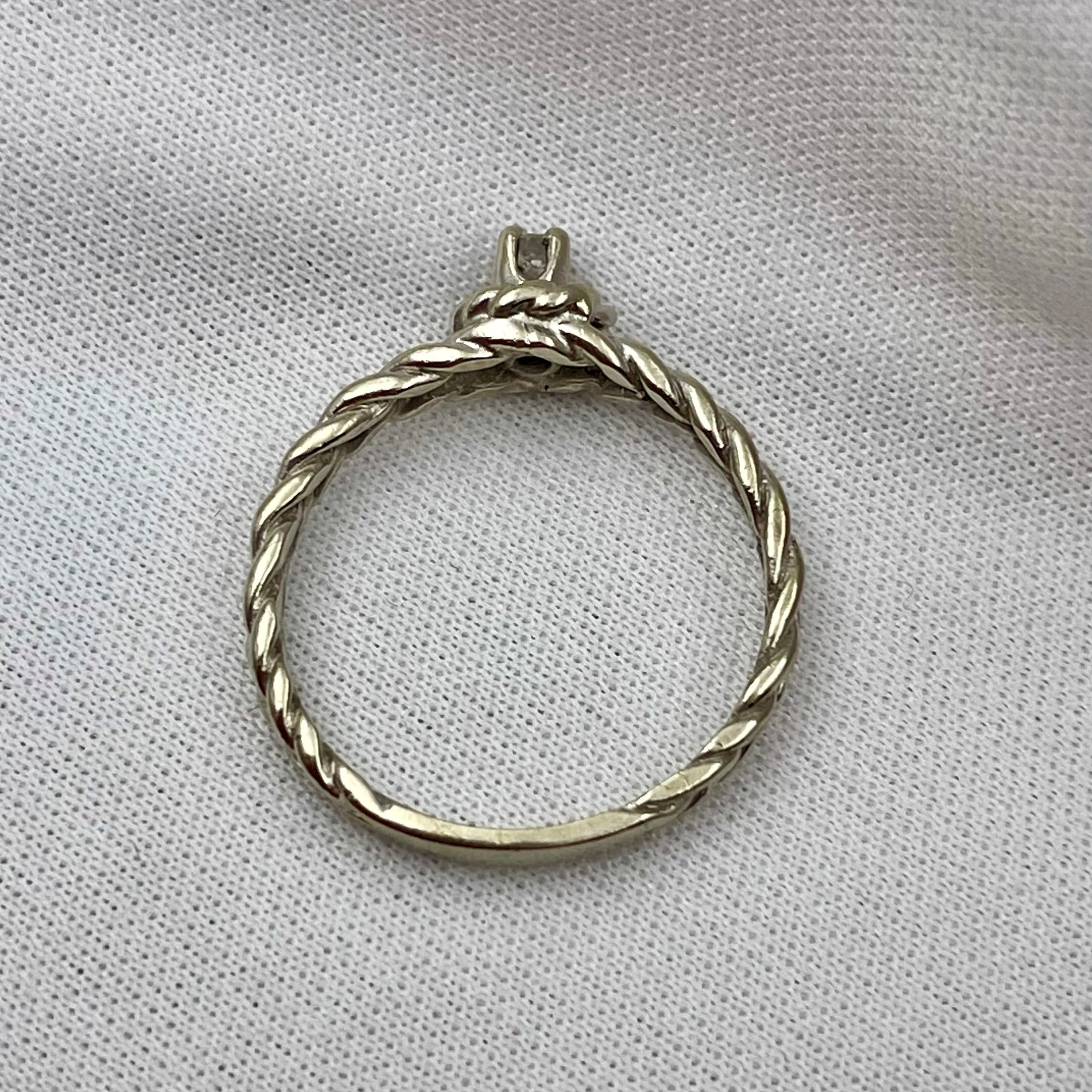 gallery view of white gold rope designed diamond promise ring in front of white fabric background