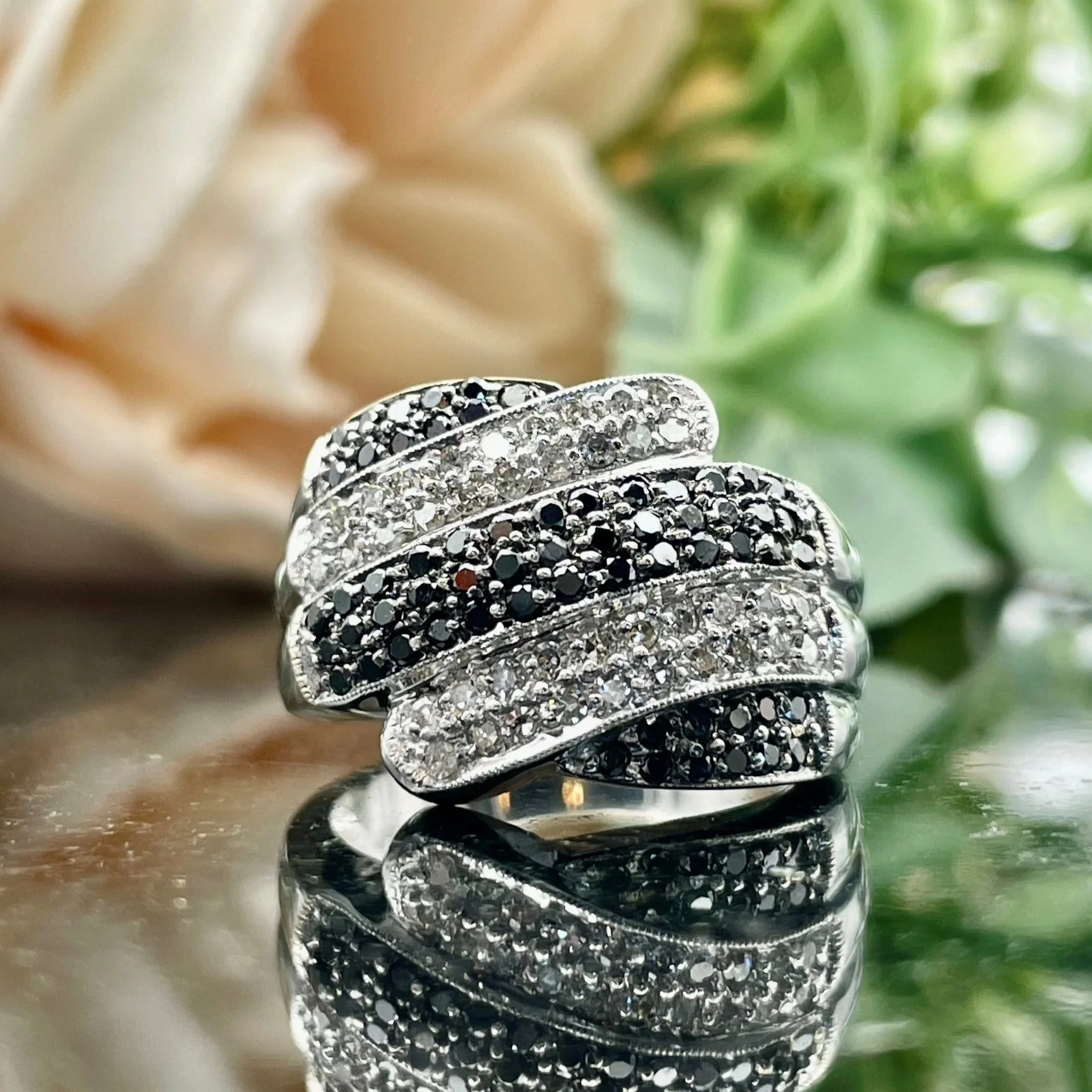 front view of 1.00ctw Black And White Diamond Fashion Wide Ladies Ring 14k White Gold in front of florals