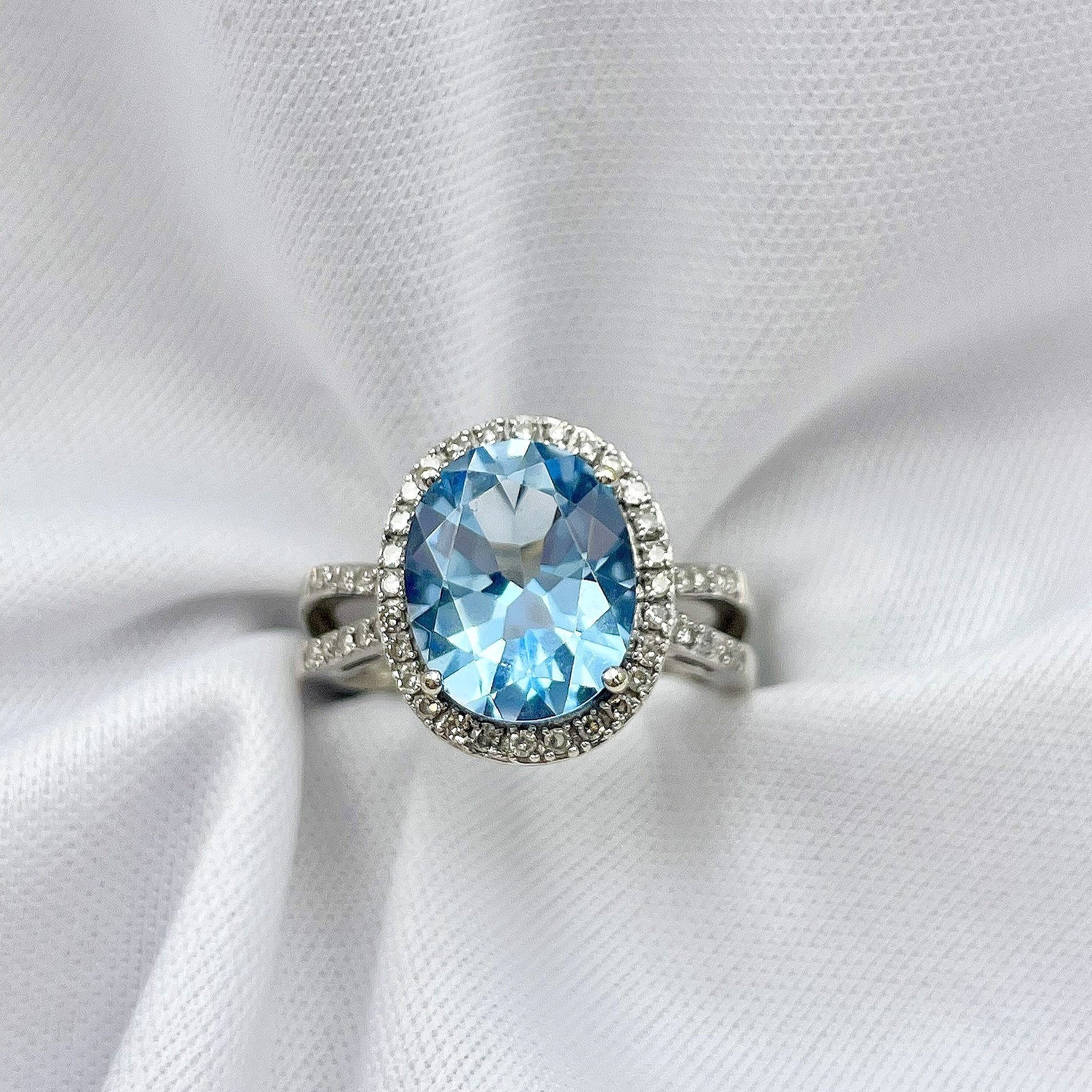 top down view white background Oval Blue Topaz With Diamond Halo And Split Shoulders 14k White Gold Ring