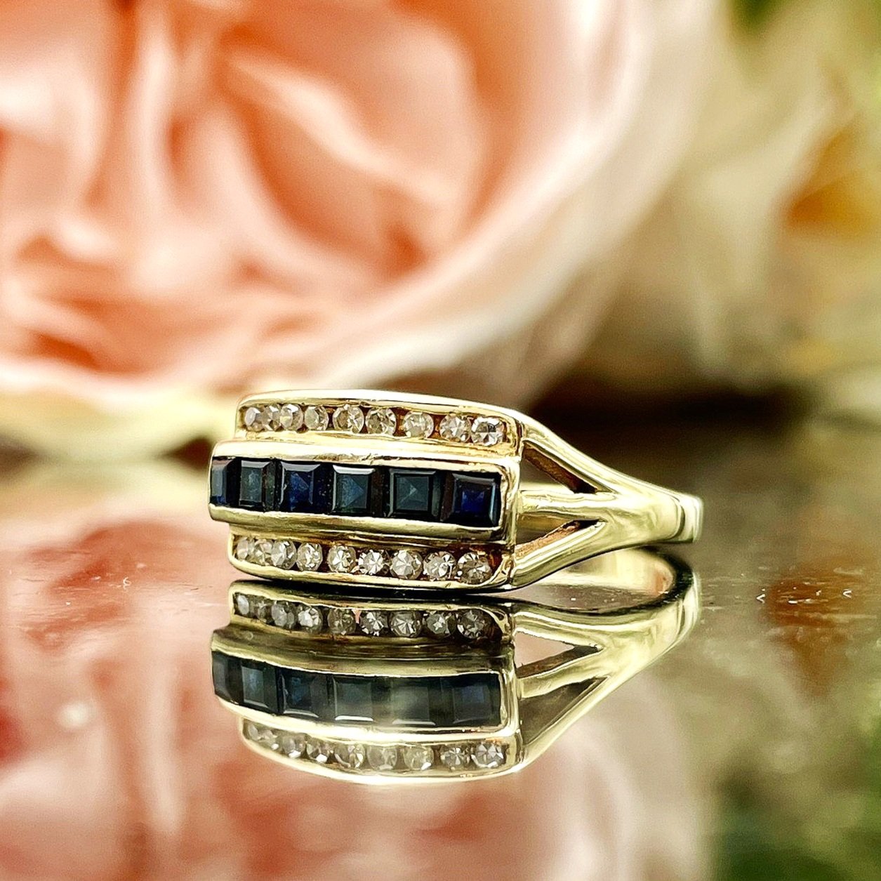 close up in front of flowers 14k Yellow Gold Channel Set Sapphire And Diamond Ladies Ring