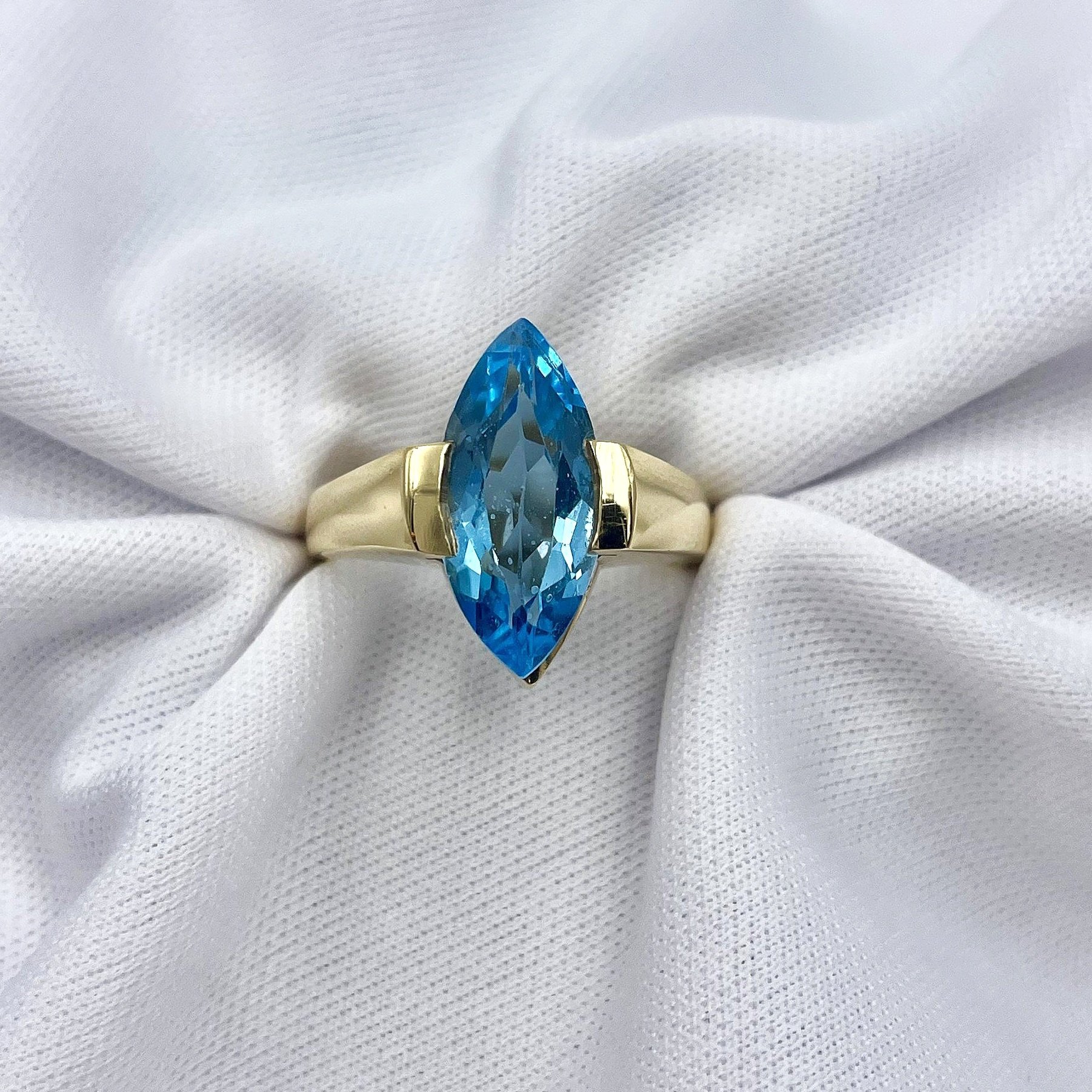 top down view white background Marquise Cut Blue Topaz Solitaire Ladies Ring 14k Yellow gold