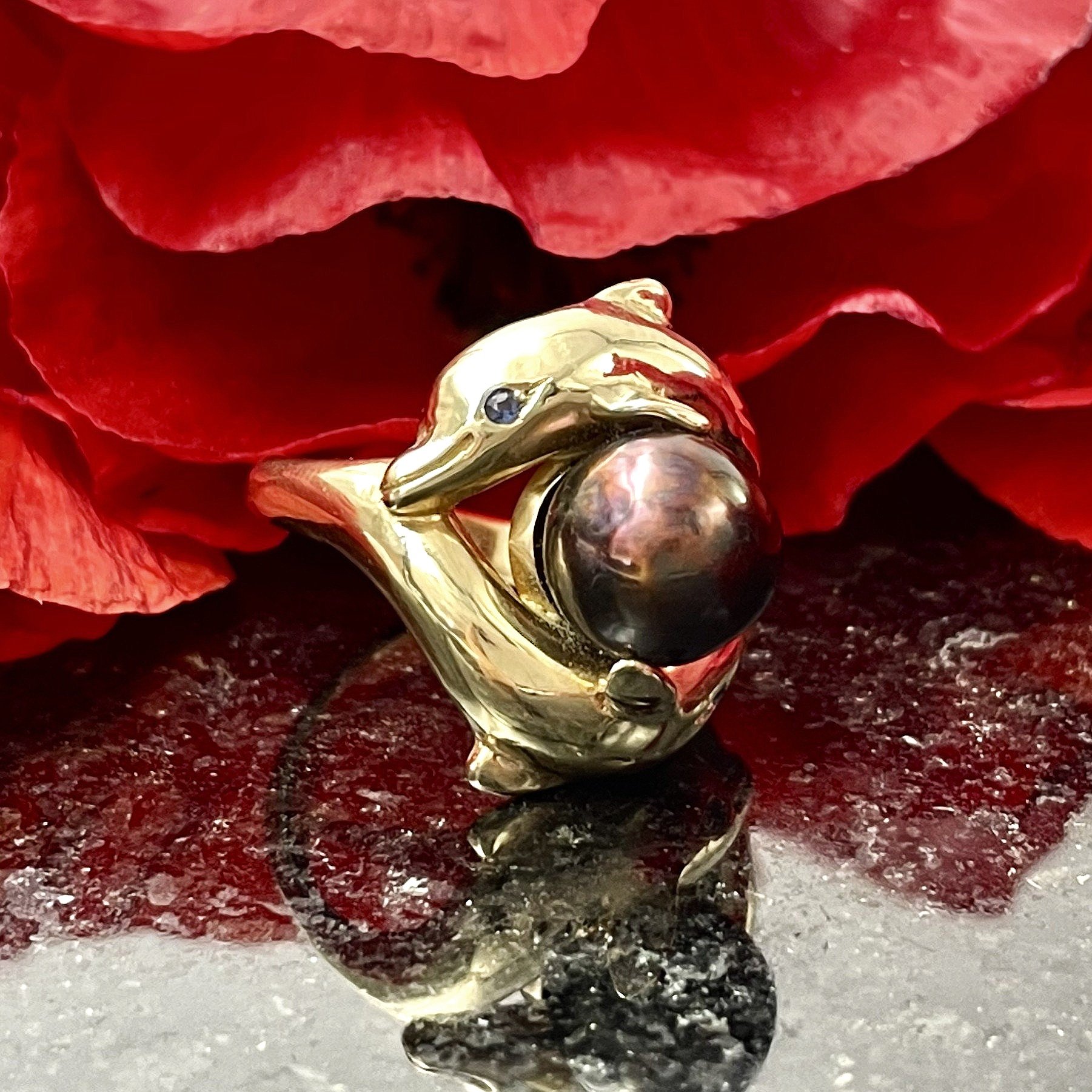 close up in front of flowers Dancing Dolphin Brown Pearl With Sapphire Accents Ring 14k Yellow Gold
