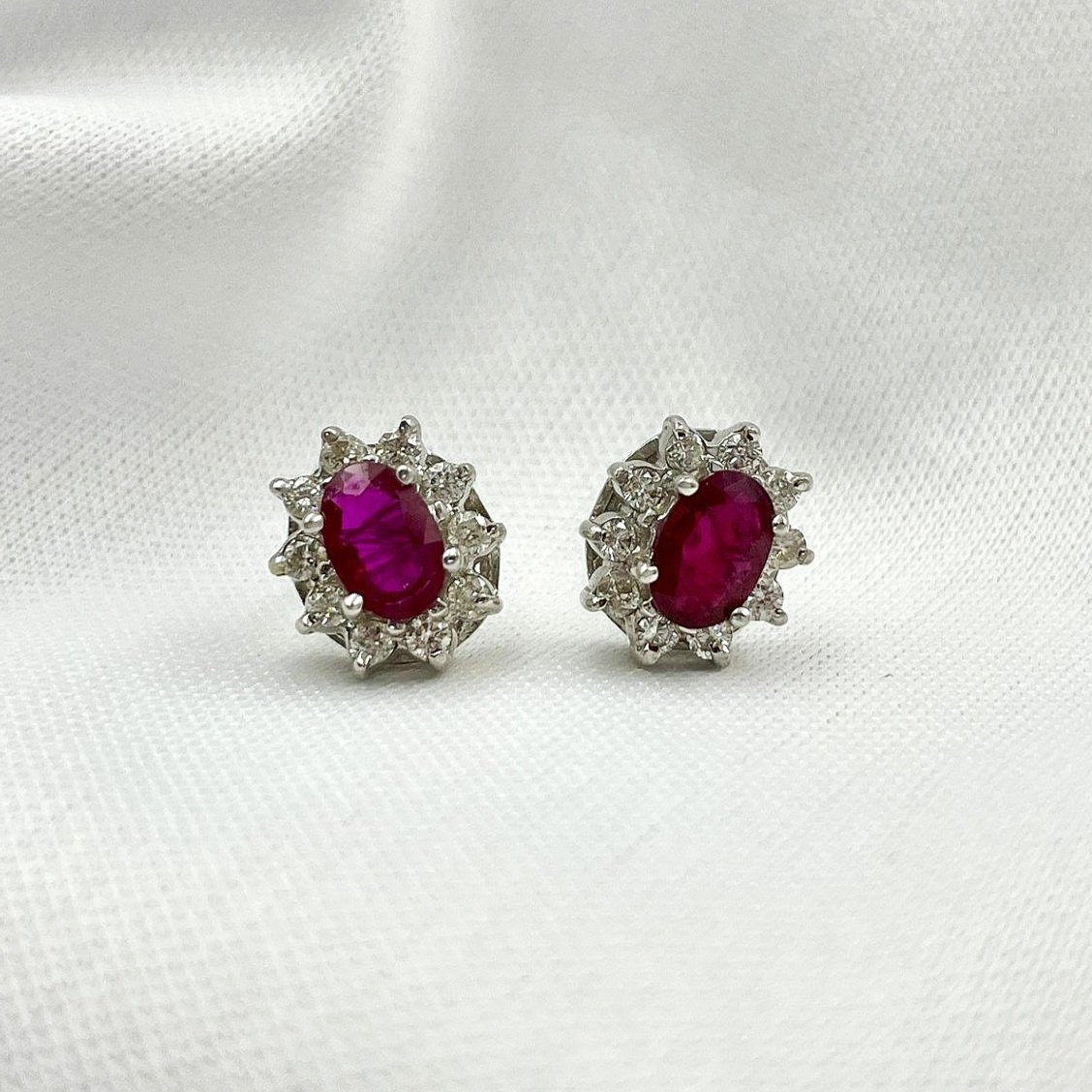 close up white background 14k White Gold 1 1/4ctw Oval Rubies With .44ctw Diamond Halos Stud Earrings