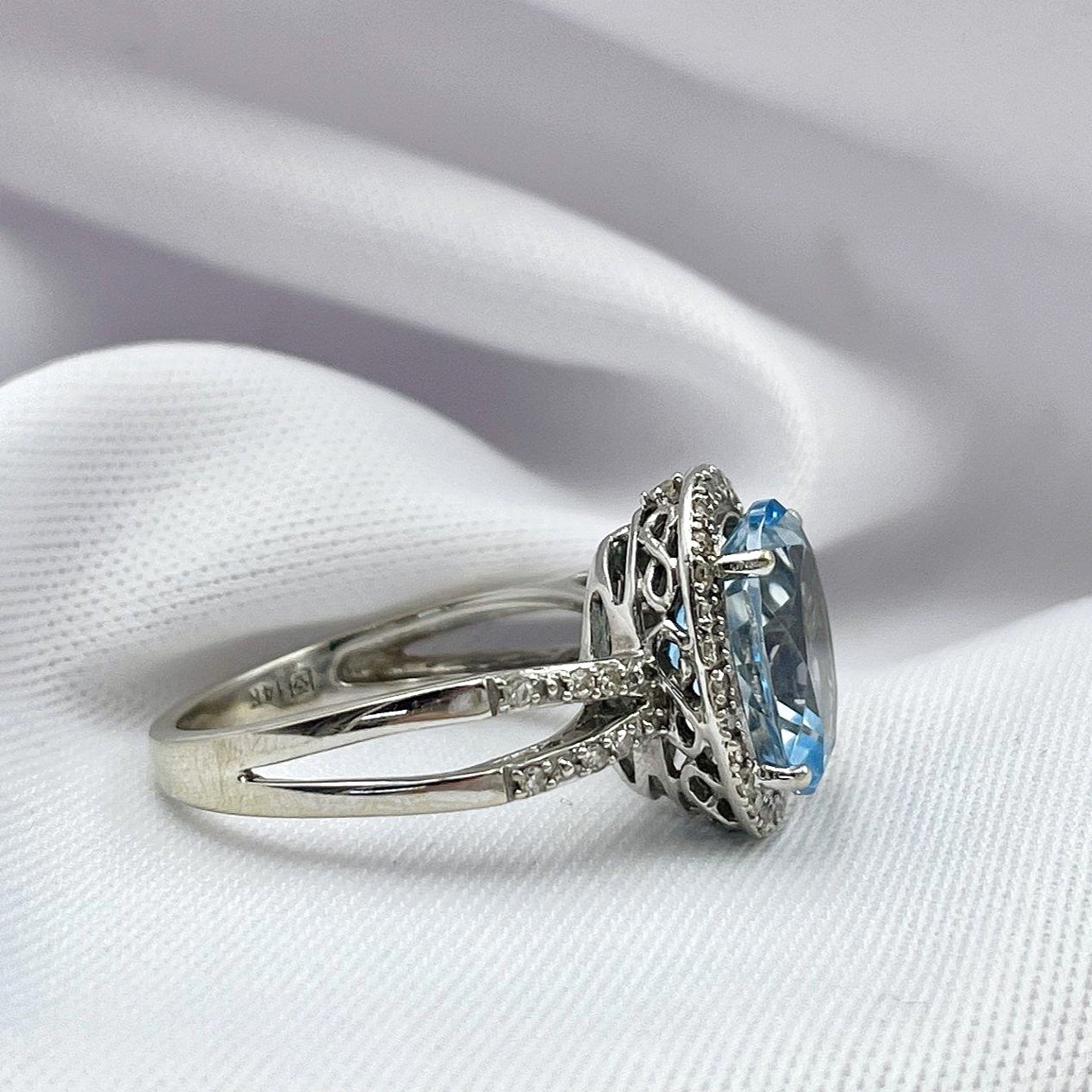 side view white background Oval Blue Topaz With Diamond Halo And Split Shoulders 14k White Gold Ring