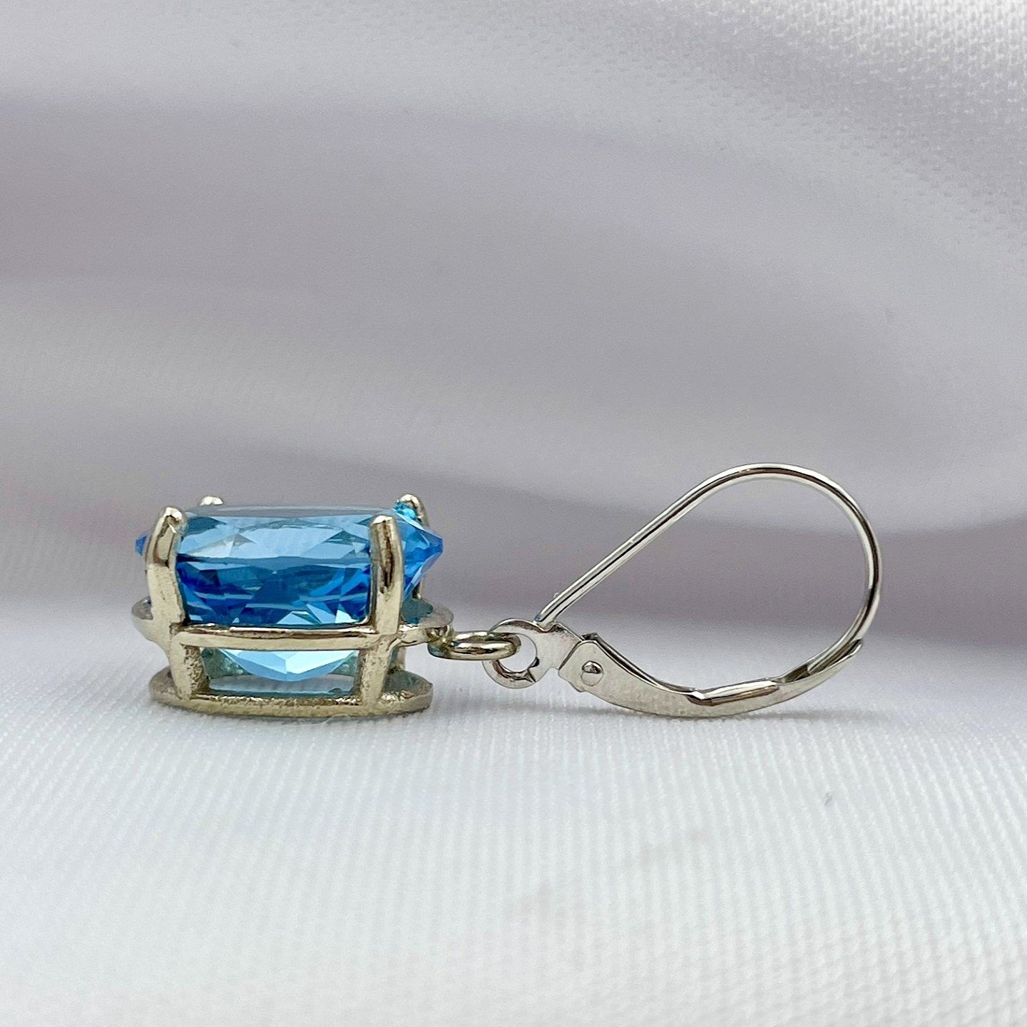 side view white background 14k White Gold 12x10mm Oval Cut Blue Topaz Drop Earrings