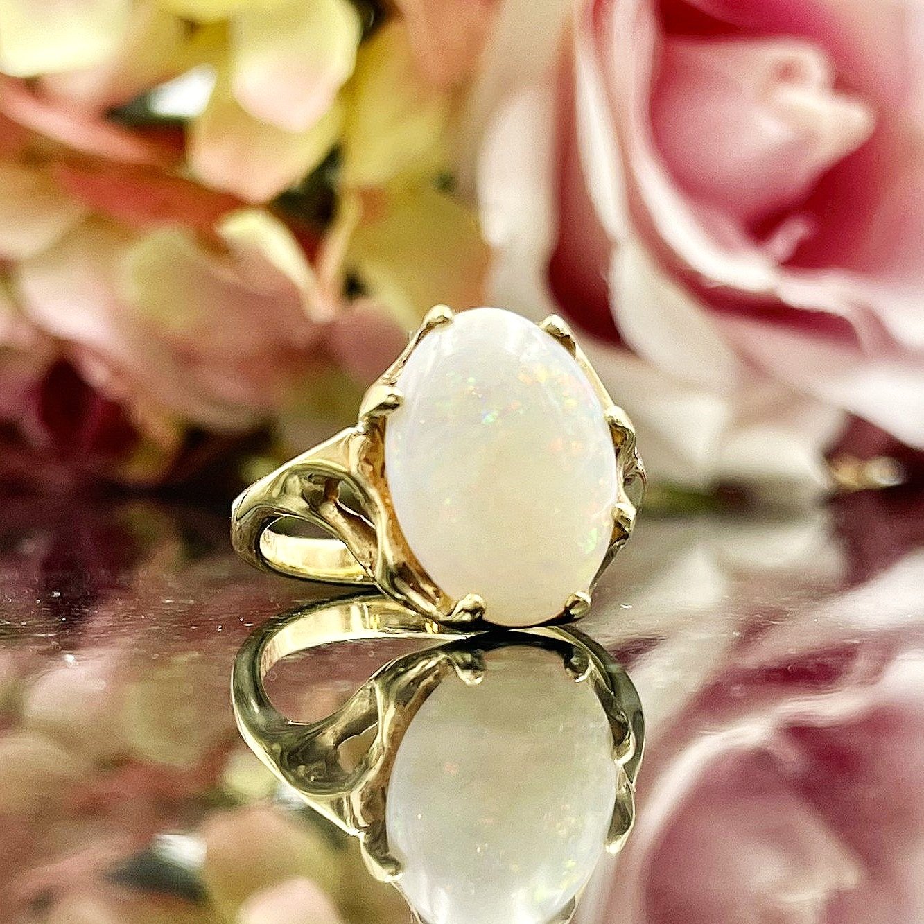 close up in front of flowers Ladies Solitaire Opal Ring Nature Inspired 14k Yellow Gold Ring