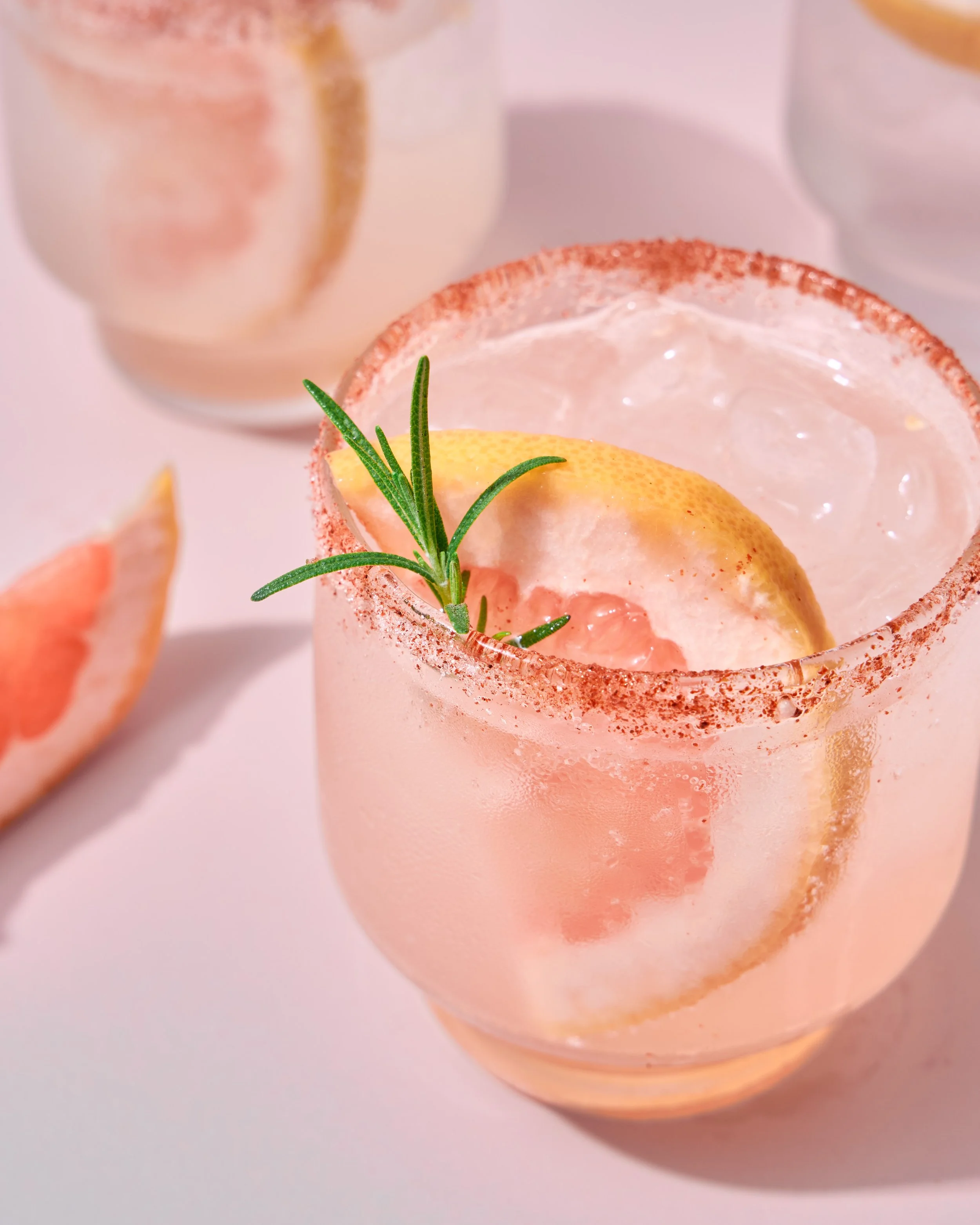 Grapefruit cocktail with sugared rim and rosemary garnish, product beverage photography by Golden Joy Photography in Los Angeles