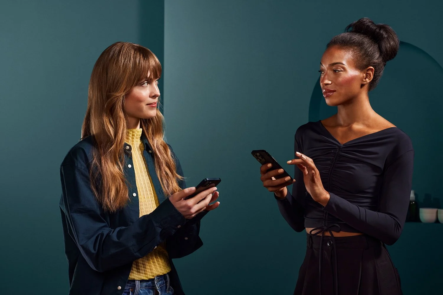Two women holding mobile phones