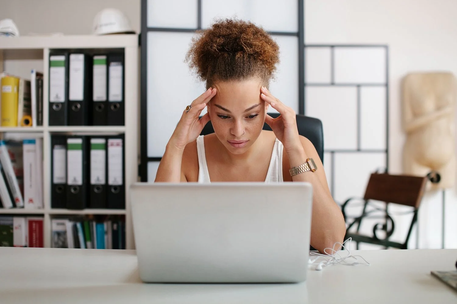 Woman staring at laptop with her head in her hands