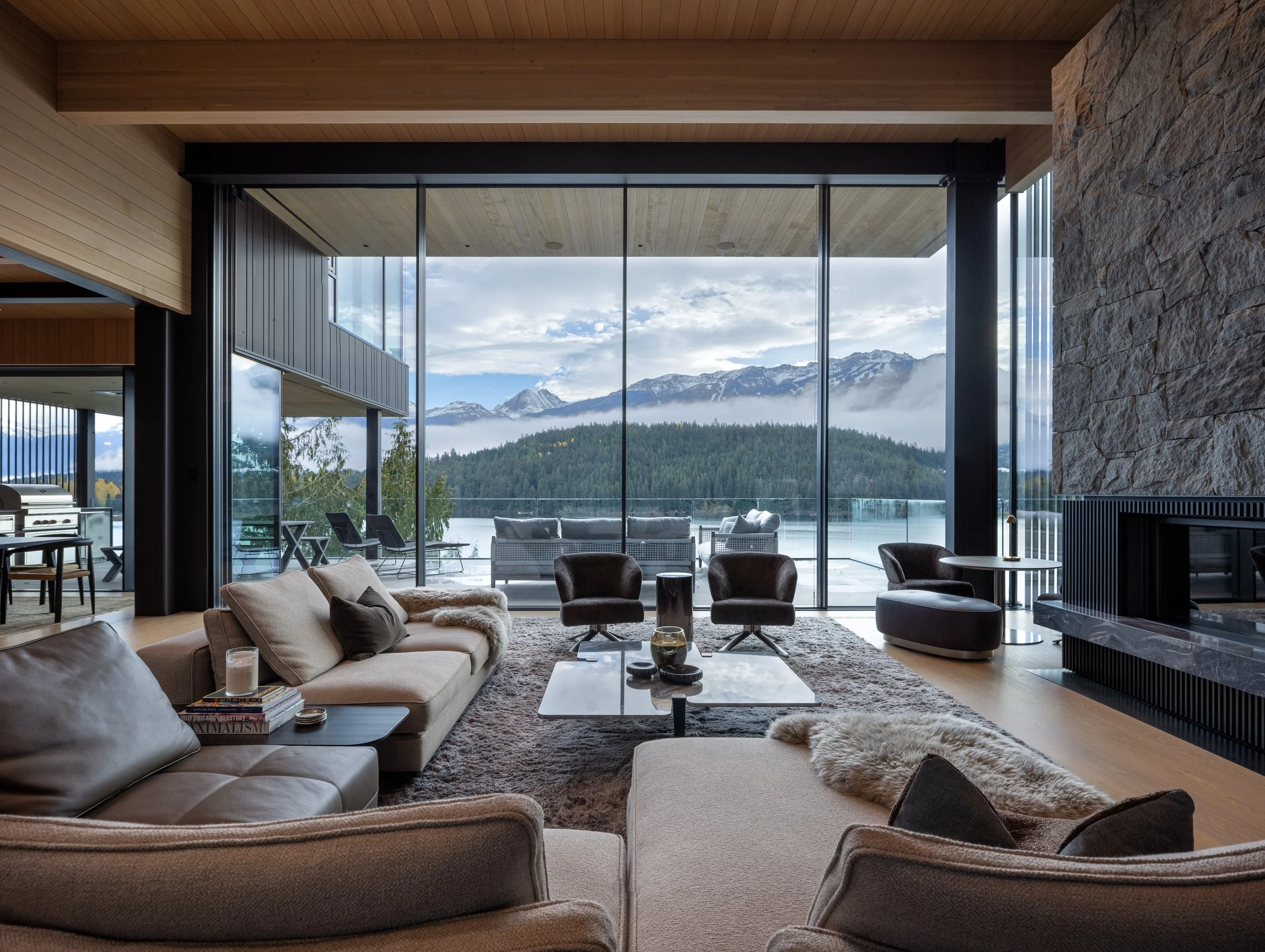 A mountain-facing living room framed by floor-to-ceiling glazing, opening directly to expansive Whistler views. This custom home by Durfeld Constructors, designed by Burgers Architecture, blurs the boundary between interior comfort and the surroundin