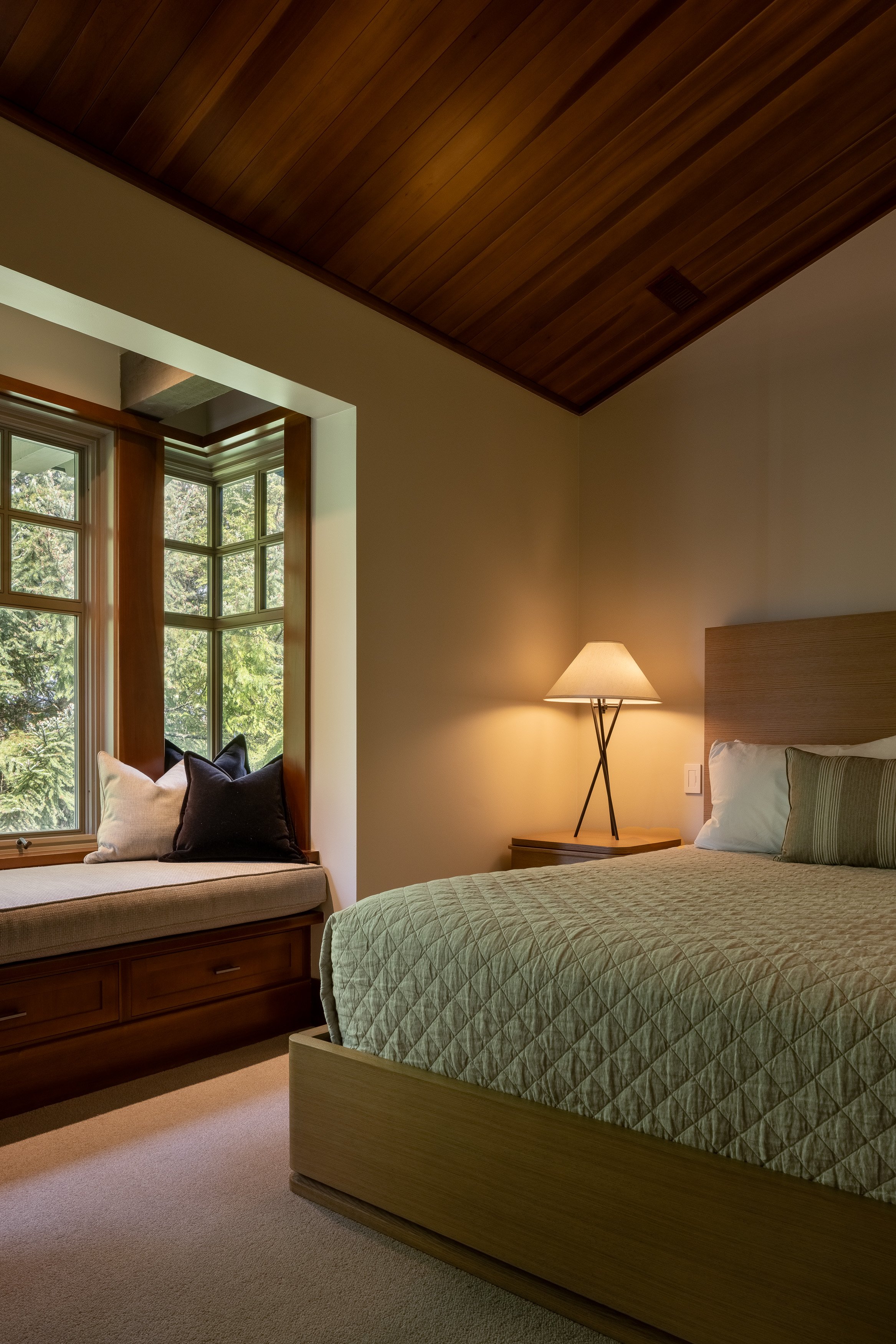 Bedroom with a built-in window seat, warm wood trim, and soft neutral styling from the Whistler interior refresh.