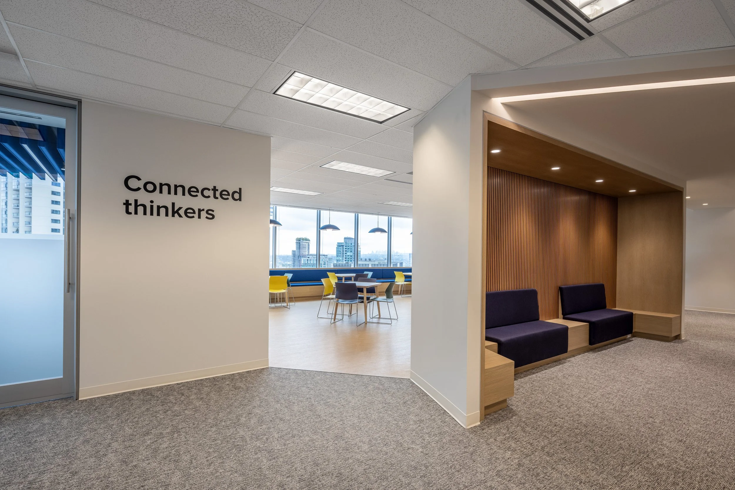 Collaborative breakout area with “Connected thinkers” wall signage and built-in seating at the Mott MacDonald Vancouver office, designed by Aura Office Interiors.