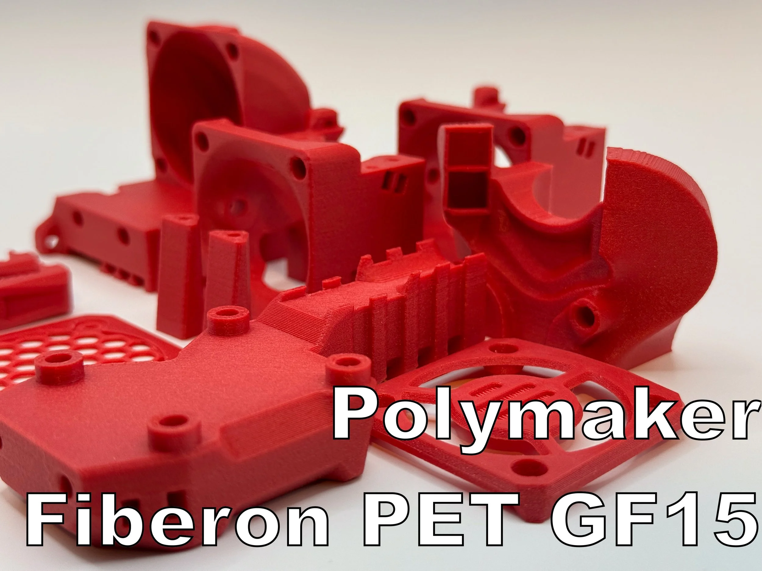 Rote 3D-gedruckte Kunststoffteile. Text: Polymaker, Fiberon PET GF15.