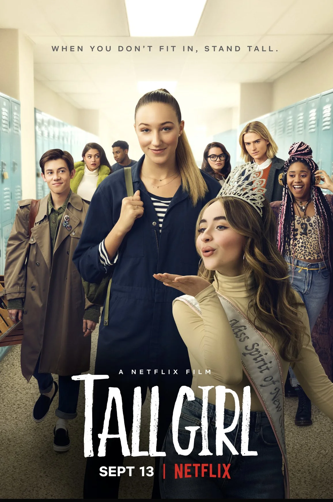 Poster for Netflix film 'Tall Girl' showing a group of diverse high school students in a hallway, with a girl wearing a tiara blowing a kiss in the foreground. The tagline reads ‘When you don’t fit in, stand tall’ and the release date is September 13