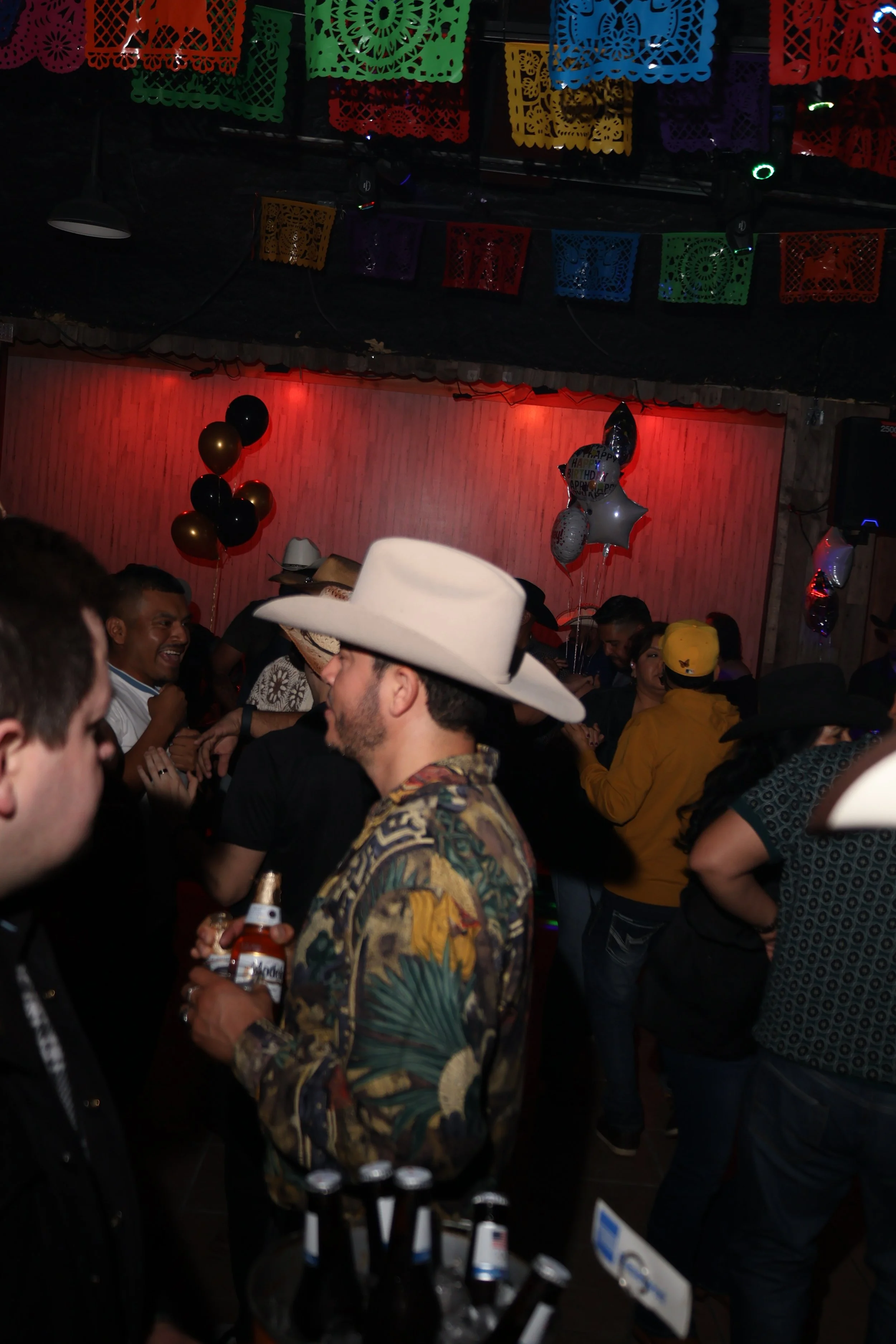 Guests wearing cowboy hats dance during Noche Vaquero at Los Robles, a Latin LGBTQ+ bar in Houston.