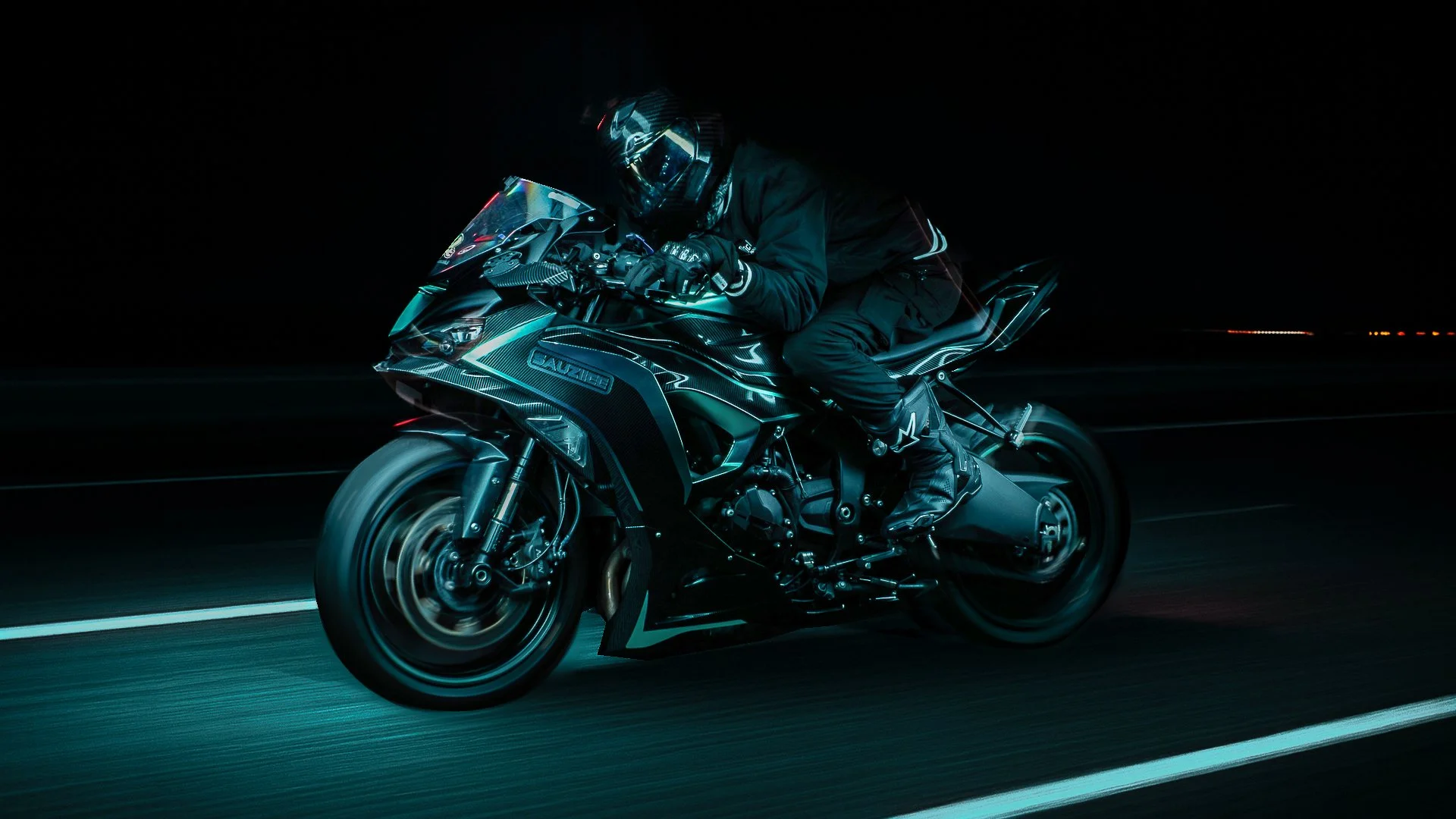 A person wearing professional motorcycle gear, including a helmet, riding a sporty black motorcycle at night with motion blur on the road.