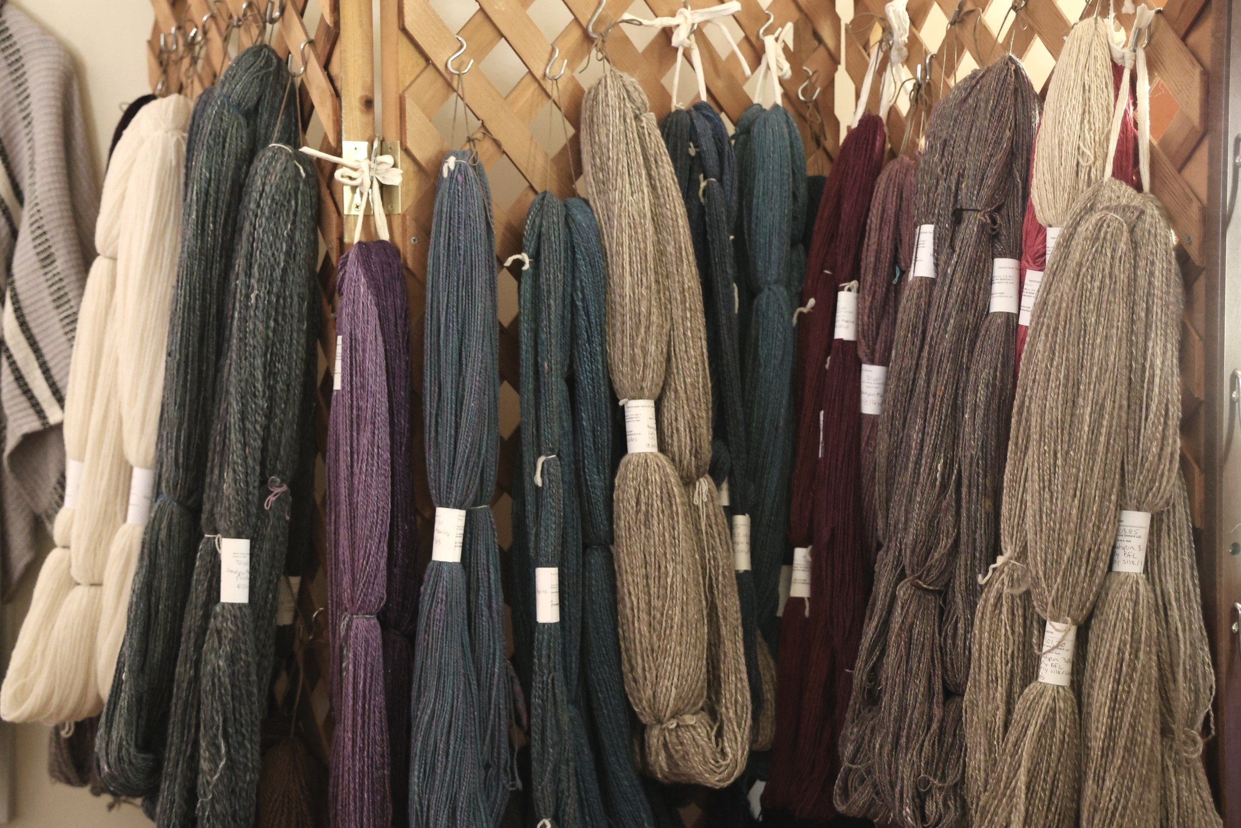 different colors of yarn hanging from the wall