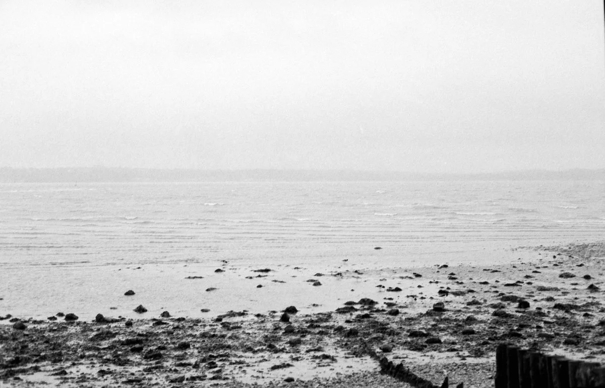 Grainy black and white film photo of the sea