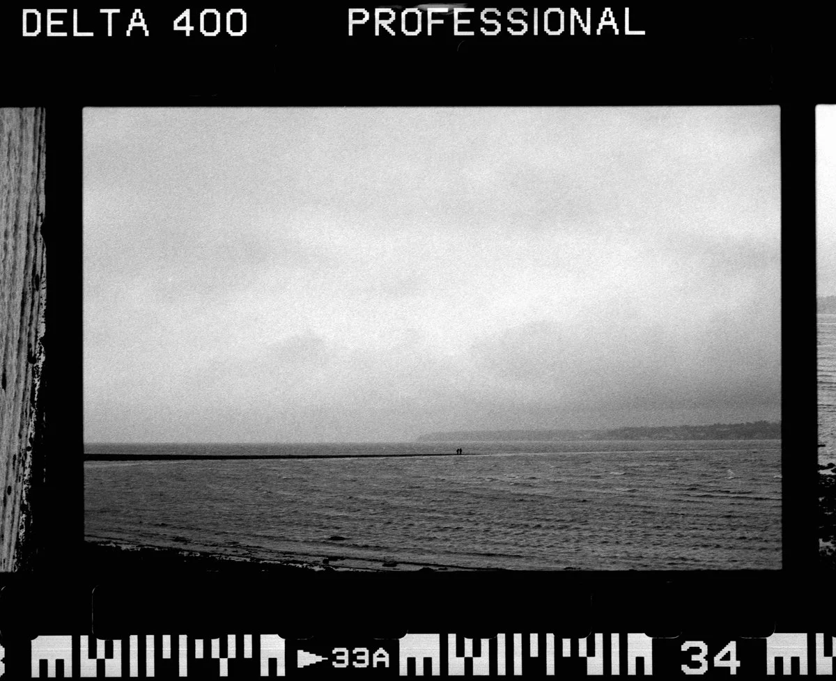 Two people walk across the spit at Lepe Beach