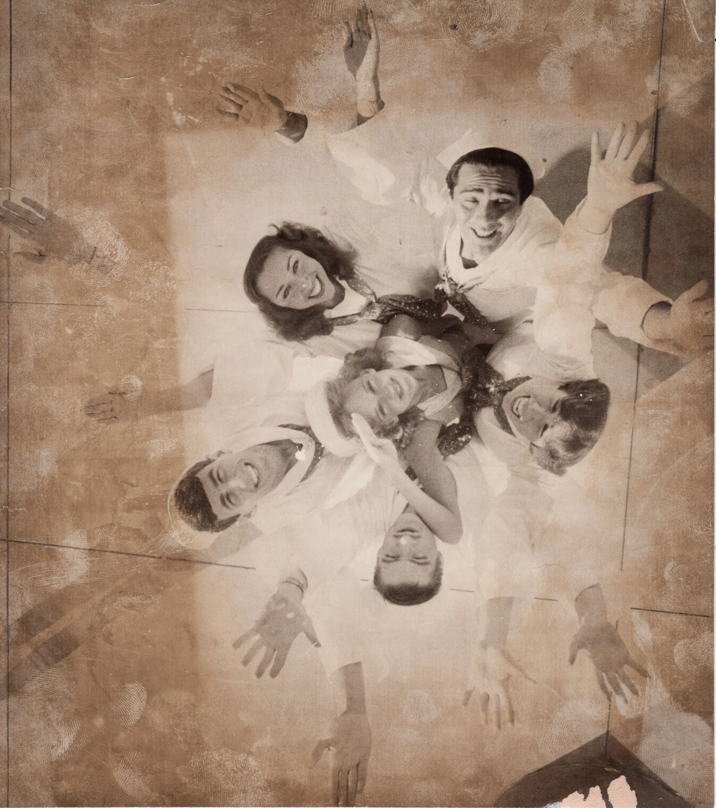 Vintage photo of four sailors and two women joyfully reaching upwards, possibly from a dance performance or film scene.