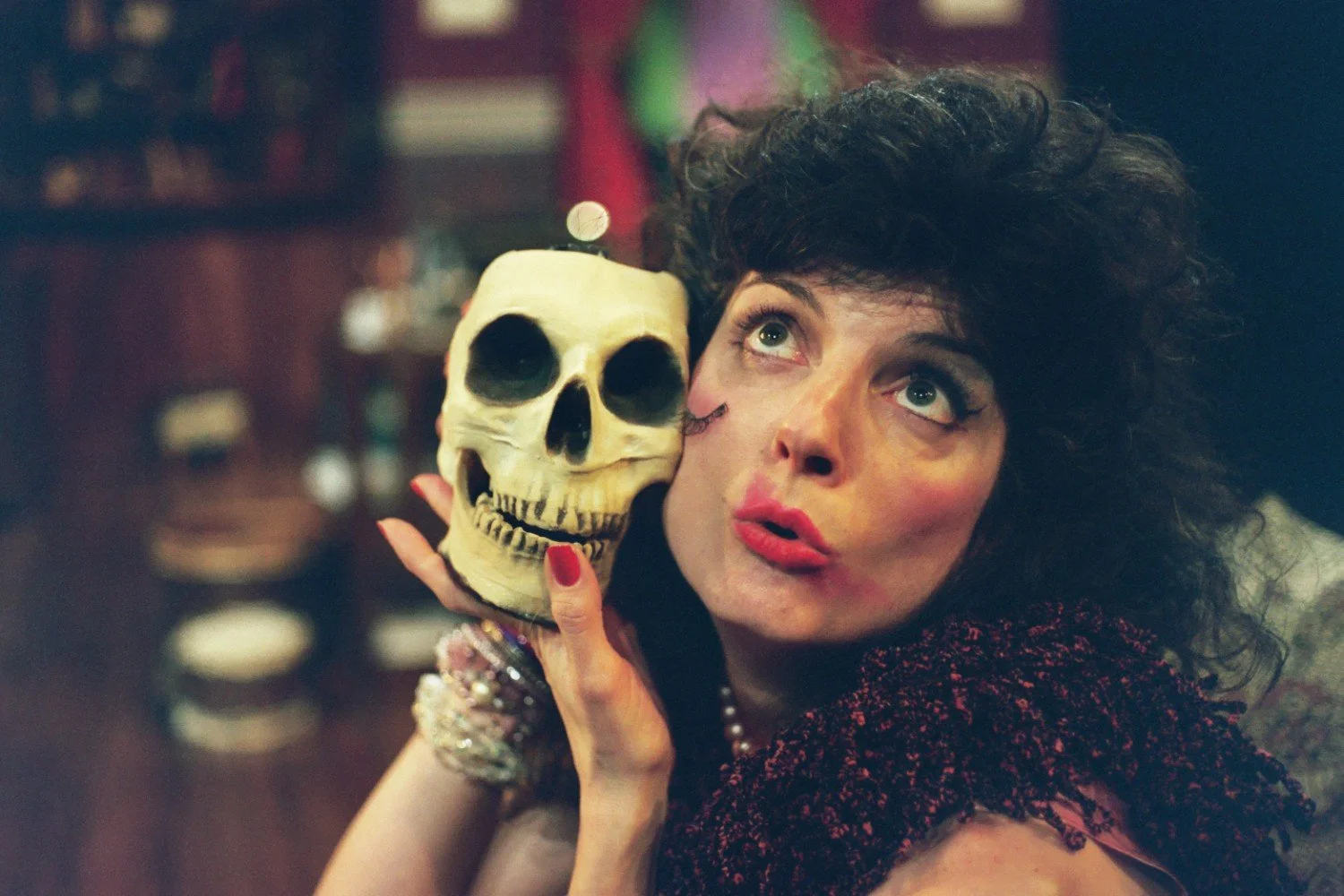 Person holding a skull and posing with dramatic expression.