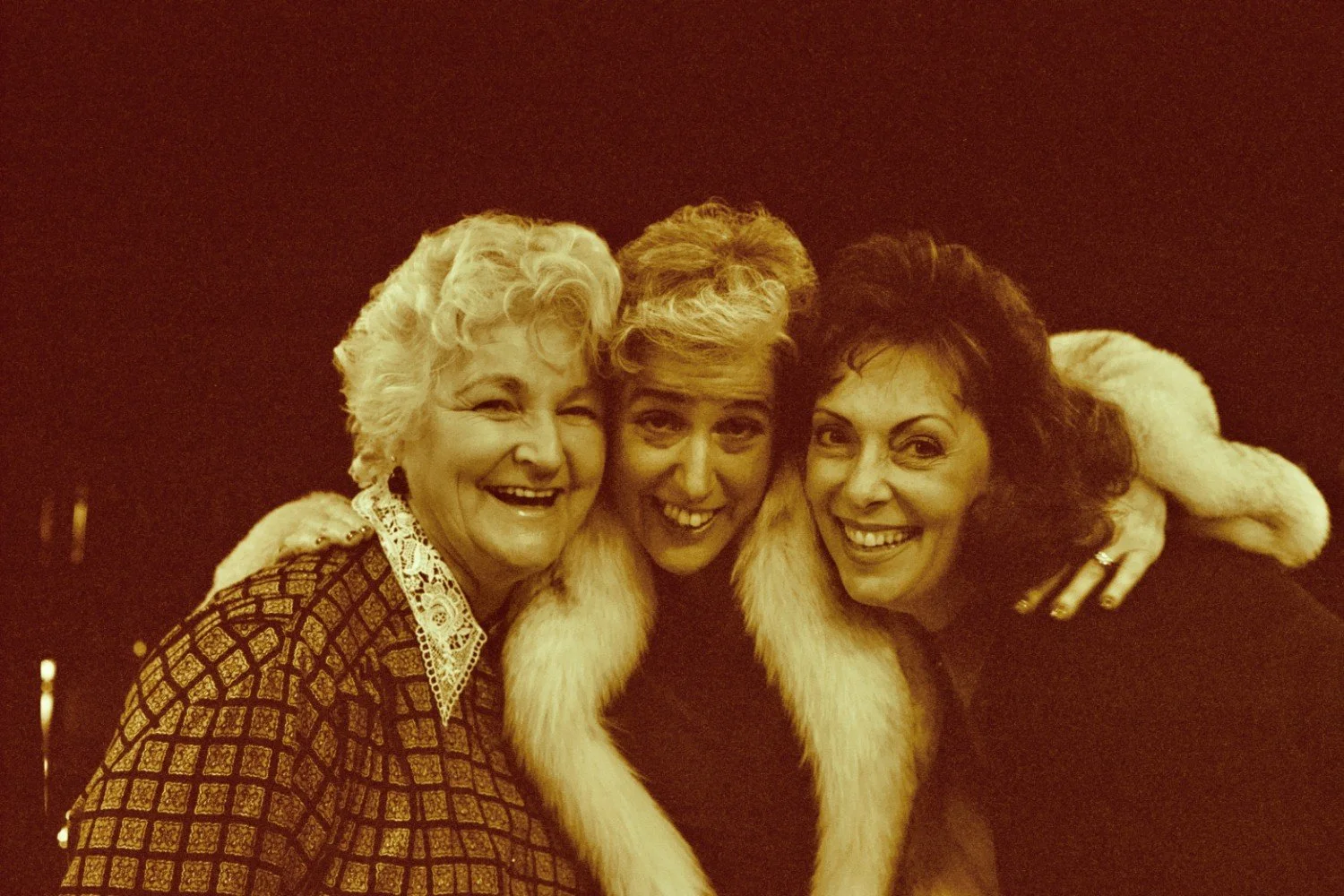 Three women smiling and posing together