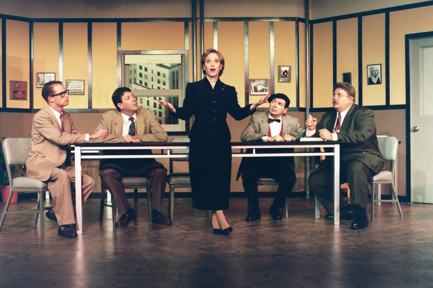 Actors performing a dramatic scene in an office setting with vintage decor.