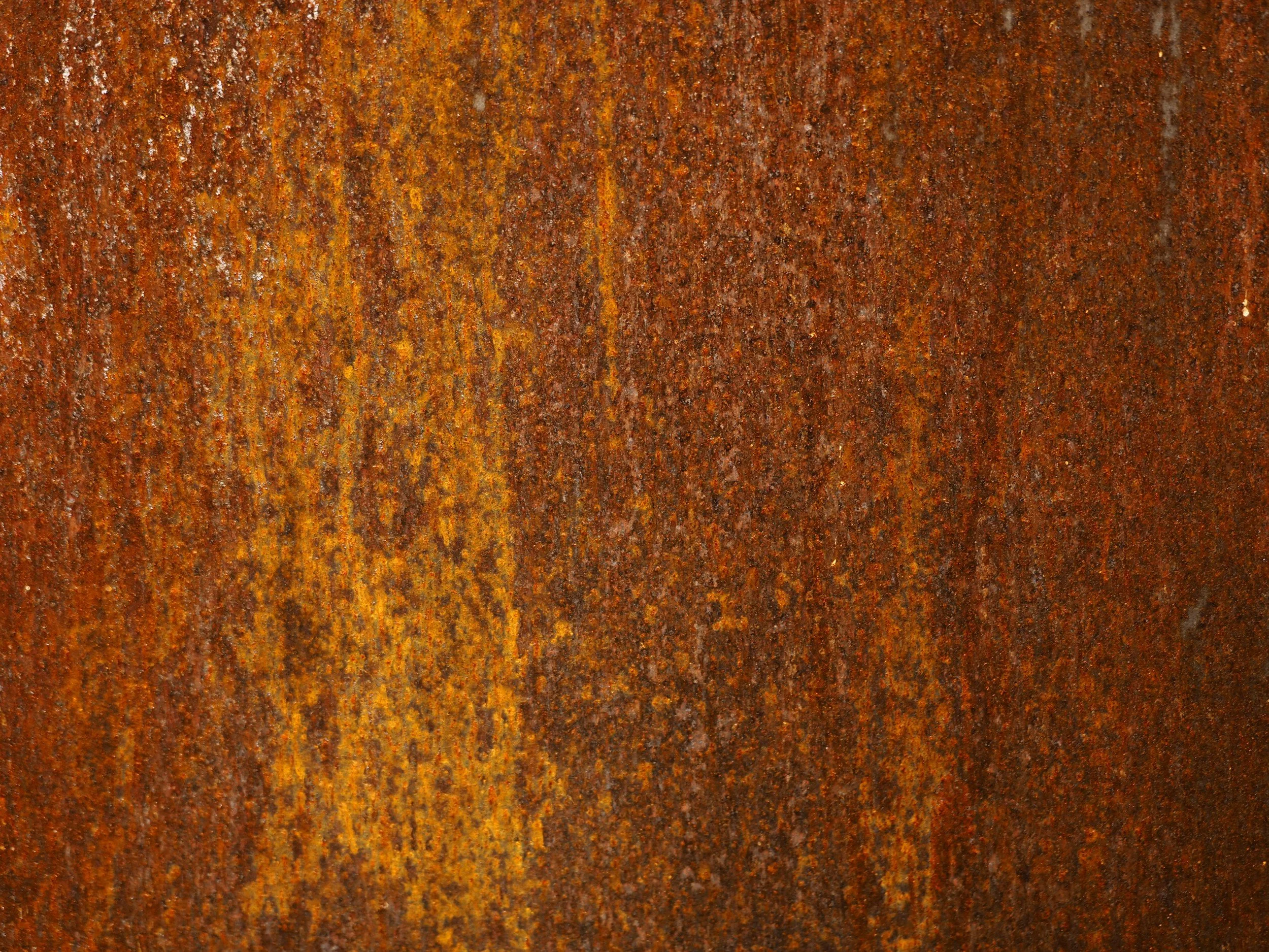Close-up of a weathered rusty metal surface with shades of orange and brown.